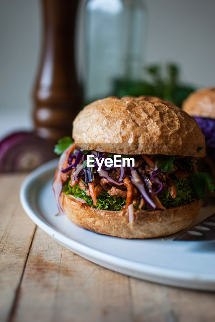 Close-up of burgers served in plate on wooden table