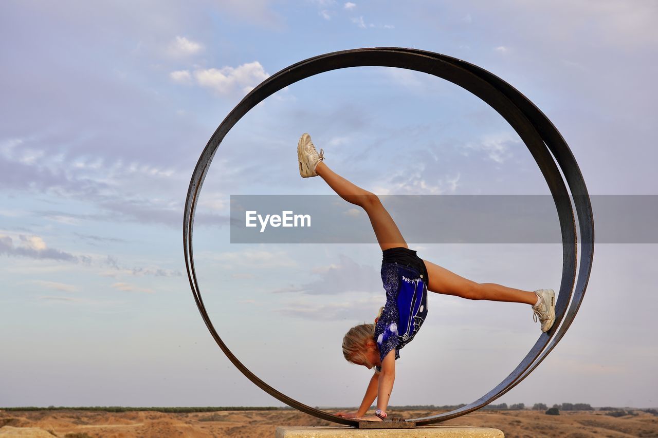 View of girl in gymnastic move in a circle