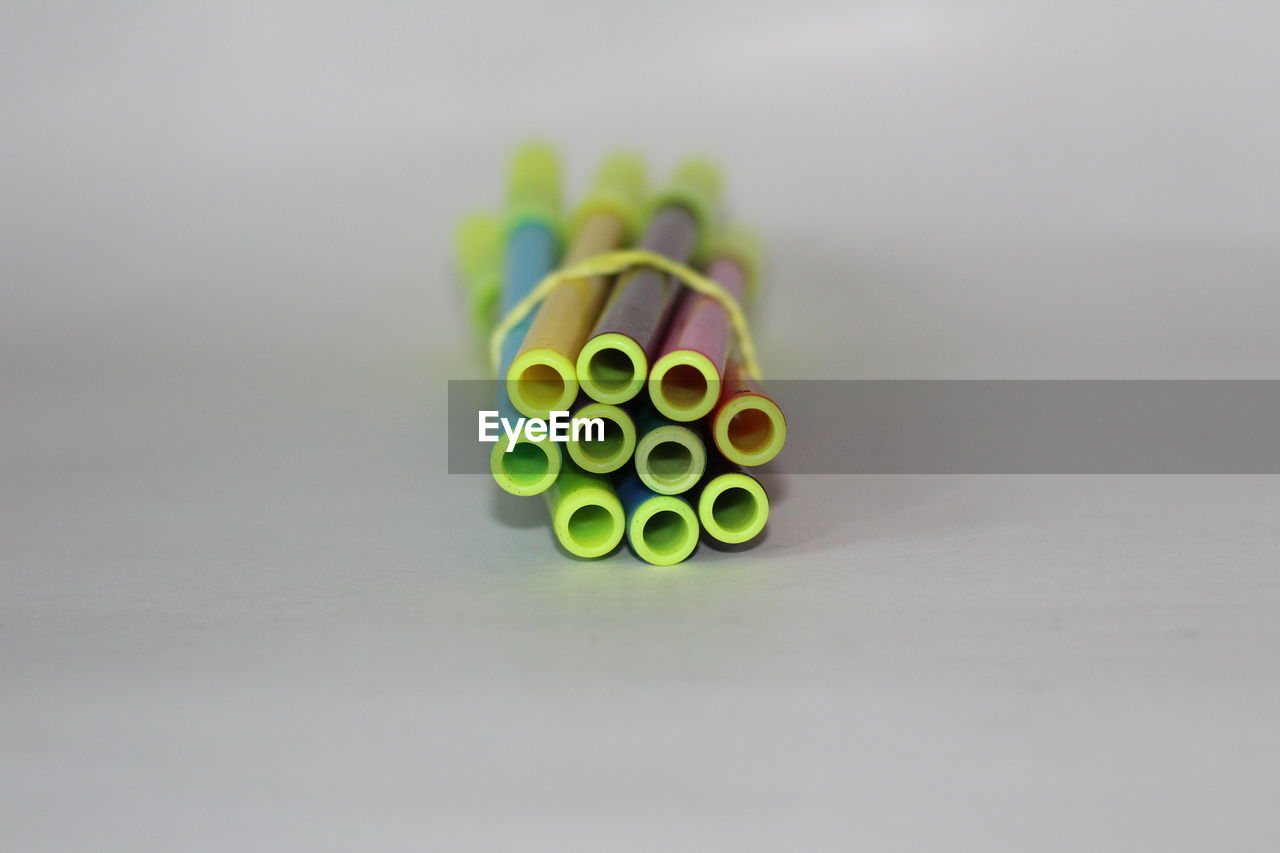 CLOSE-UP OF MULTI COLORED PENCILS ON WHITE TABLE