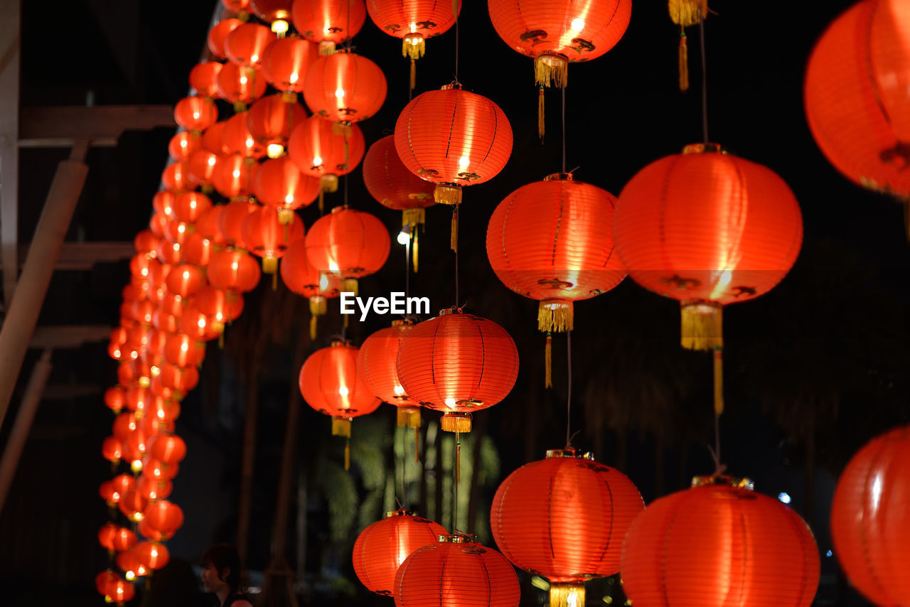 Low angle view of red illuminated lanterns hanging at night