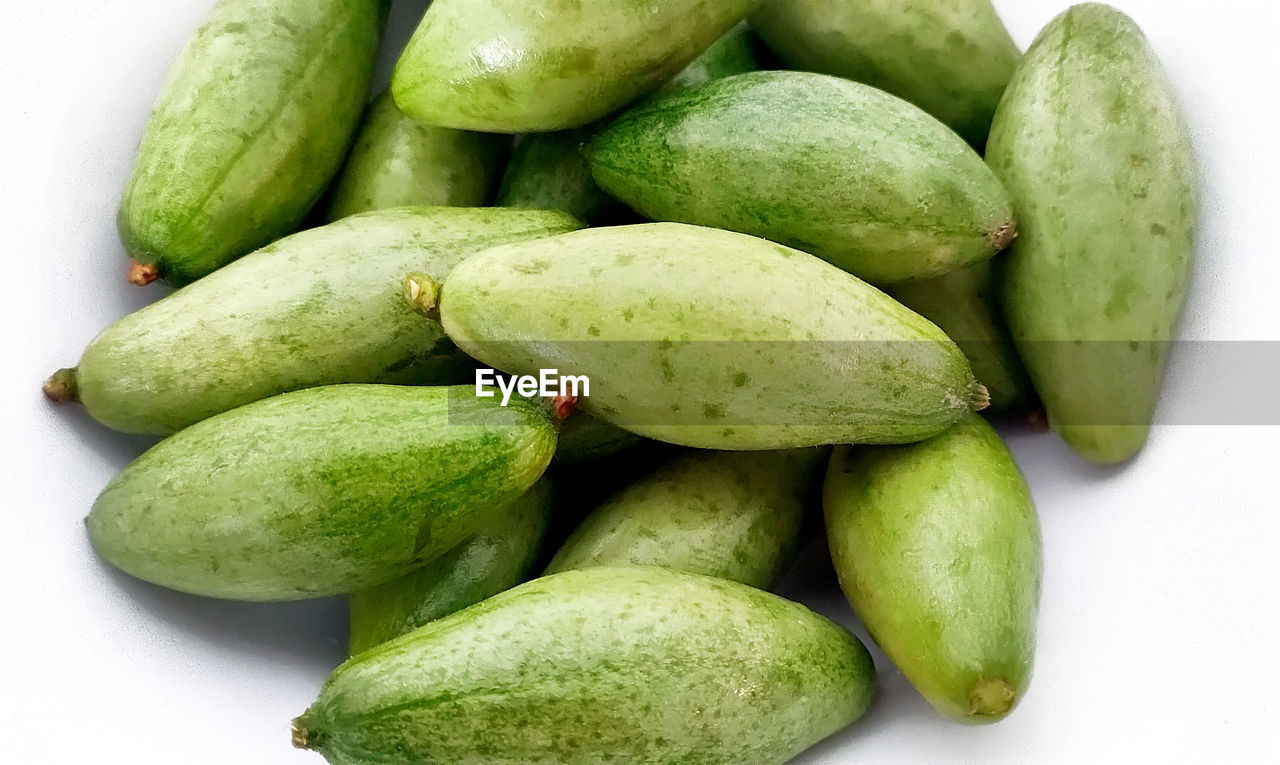 HIGH ANGLE VIEW OF GREEN FRUITS IN CONTAINER