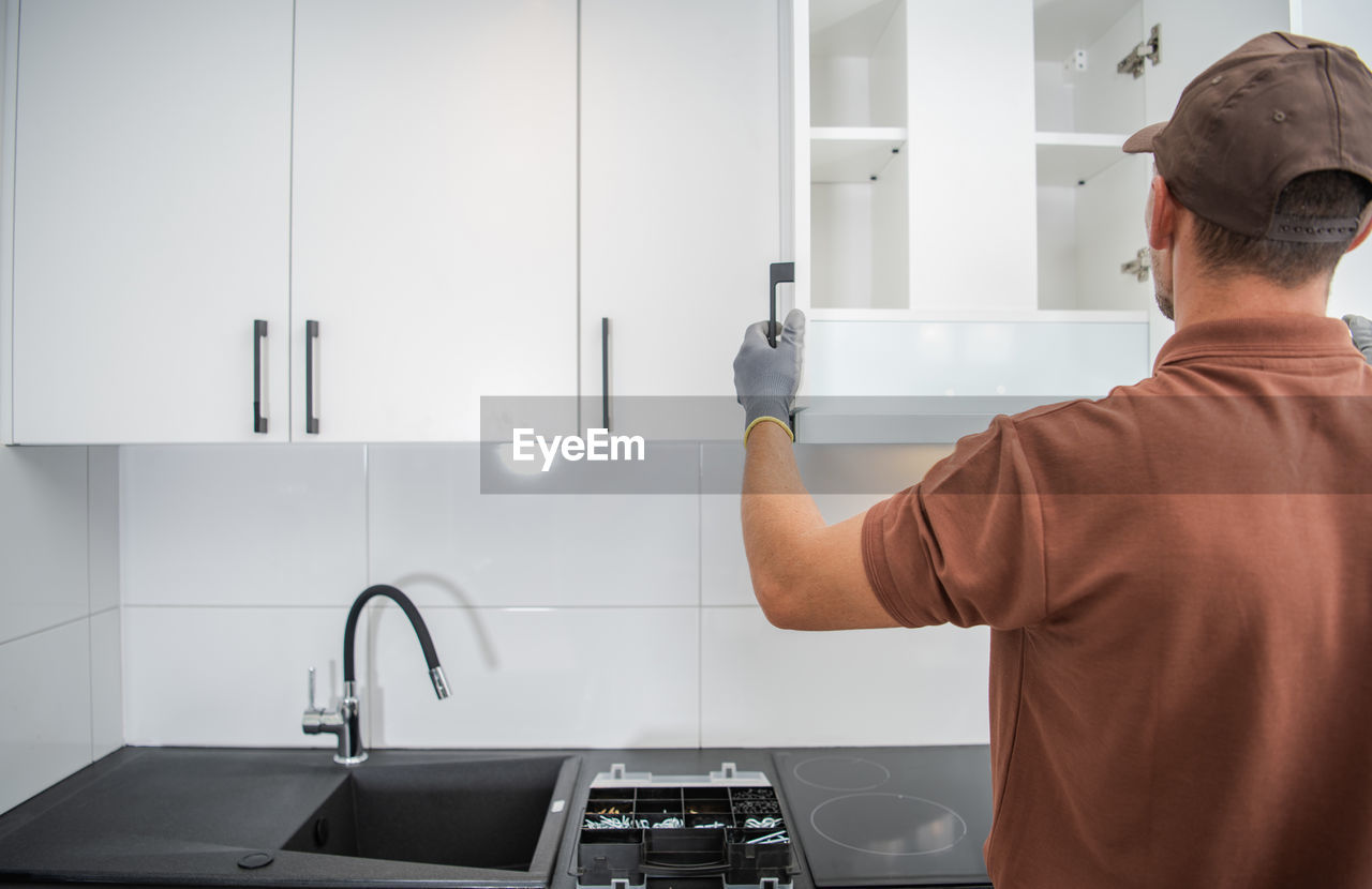 rear view of man working in bathroom