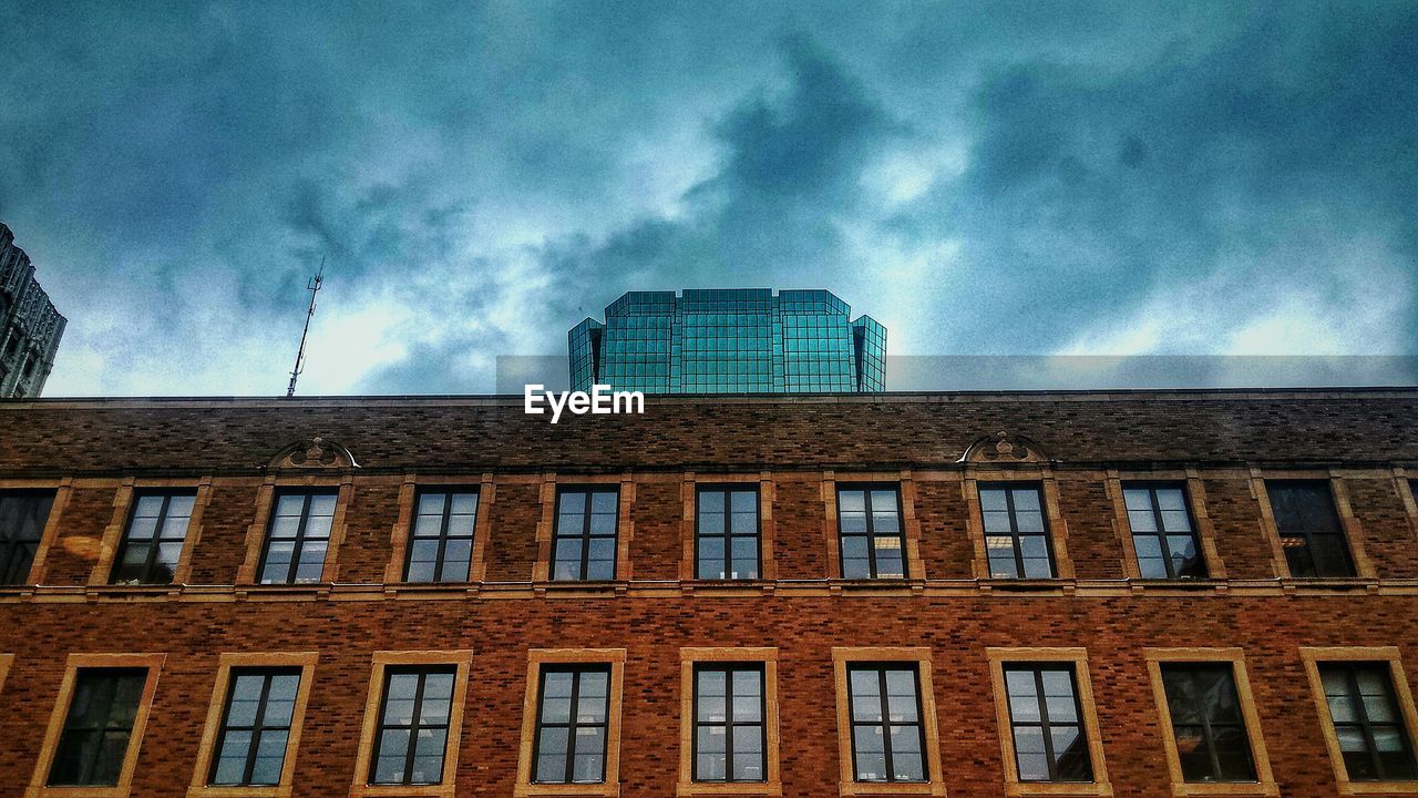 LOW ANGLE VIEW OF BUILDINGS AGAINST CLOUDY SKY