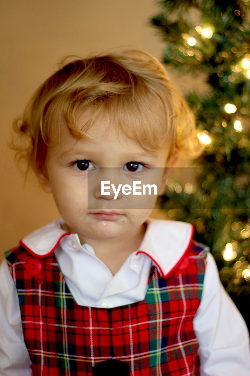 Portrait of cute boy against christmas tree