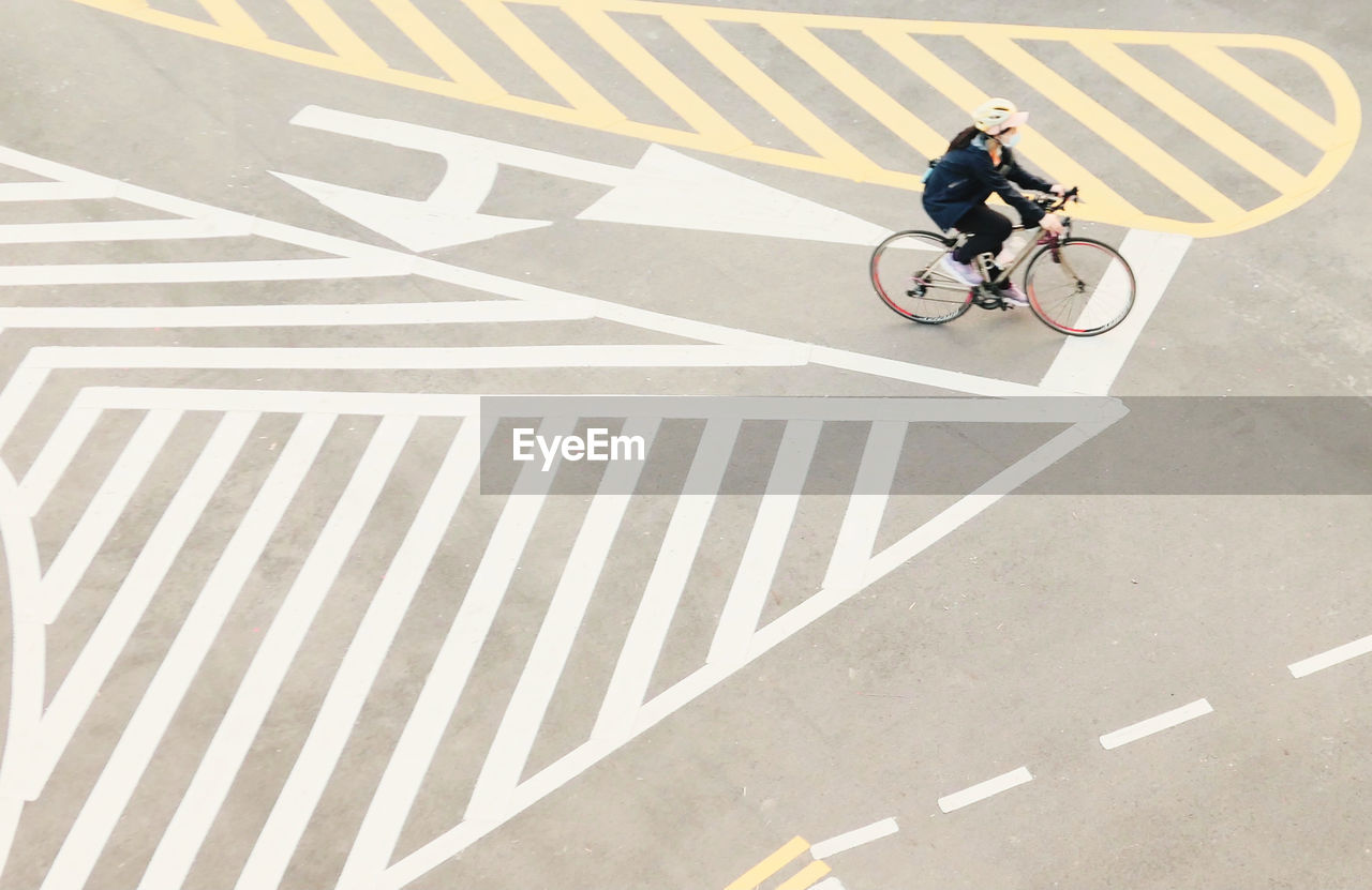 MAN RIDING BICYCLE ON ZEBRA CROSSING