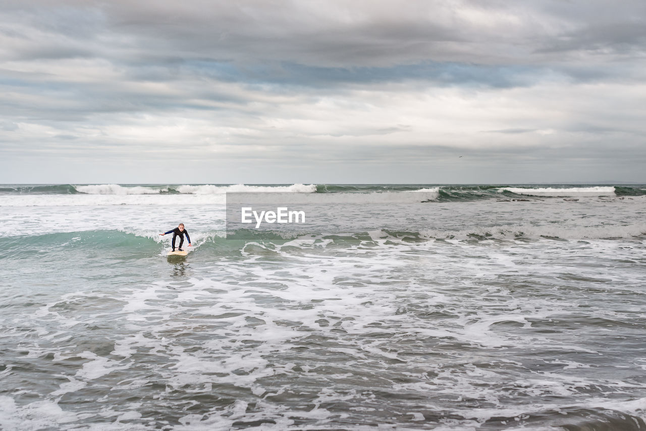 Young girl surfing on a wave in the ocean