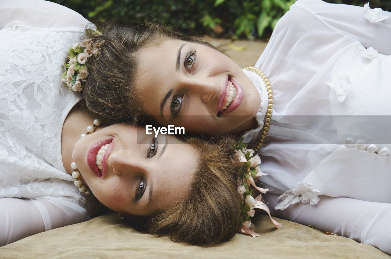 Portrait of smiling bride lying down with friend