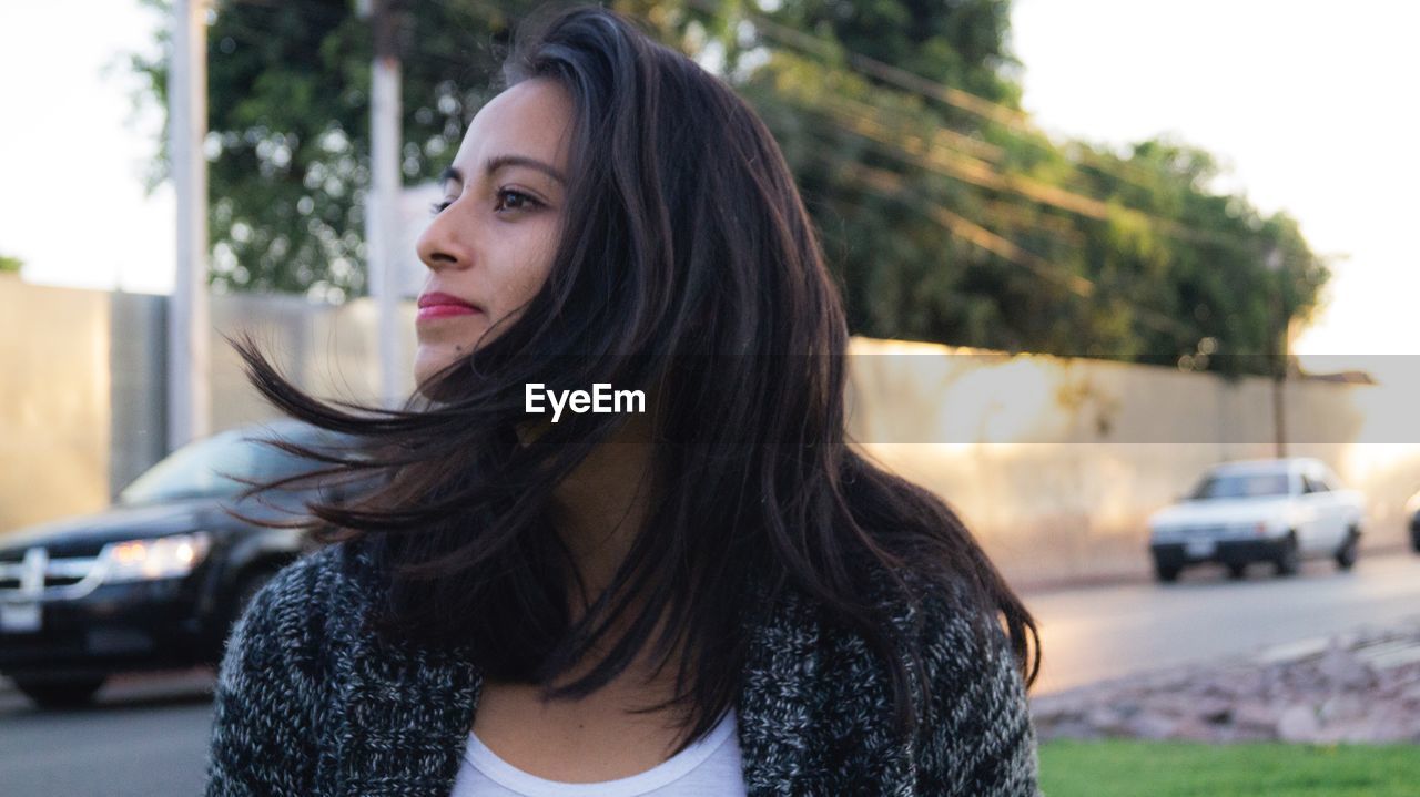 Close-up of young woman with long hair outdoors