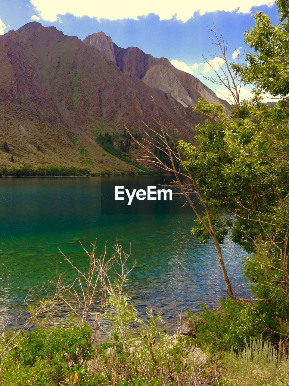 Scenic view of calm lake against cloudy sky