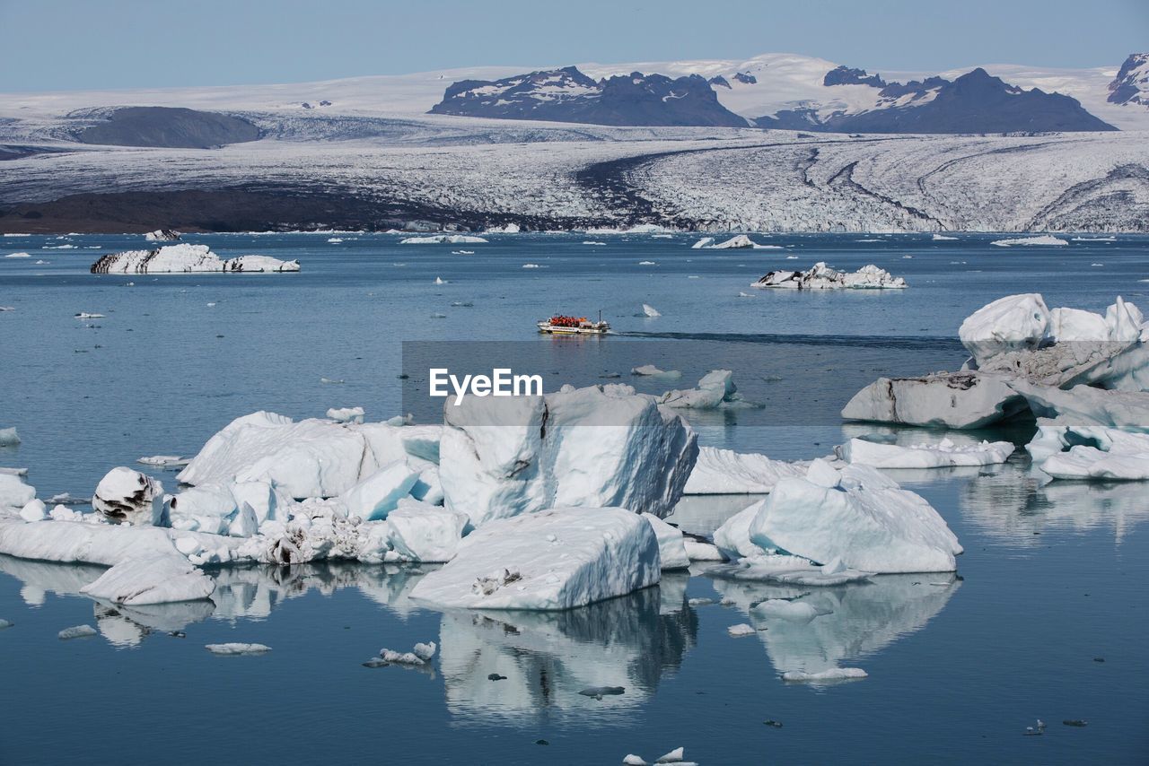 Scenic view of lake and snowcapped mountains against sky