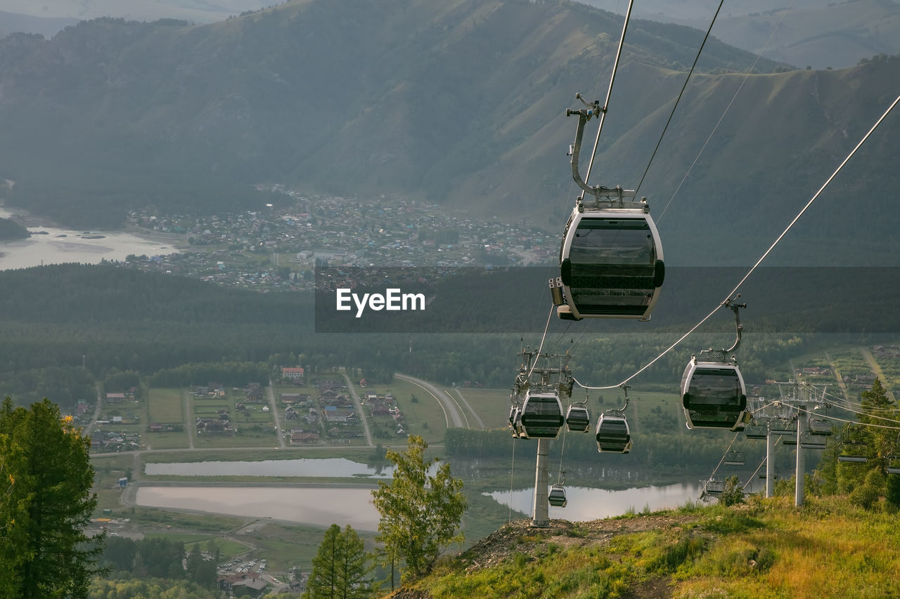 HIGH ANGLE VIEW OF OVERHEAD CABLE CAR AGAINST MOUNTAINS