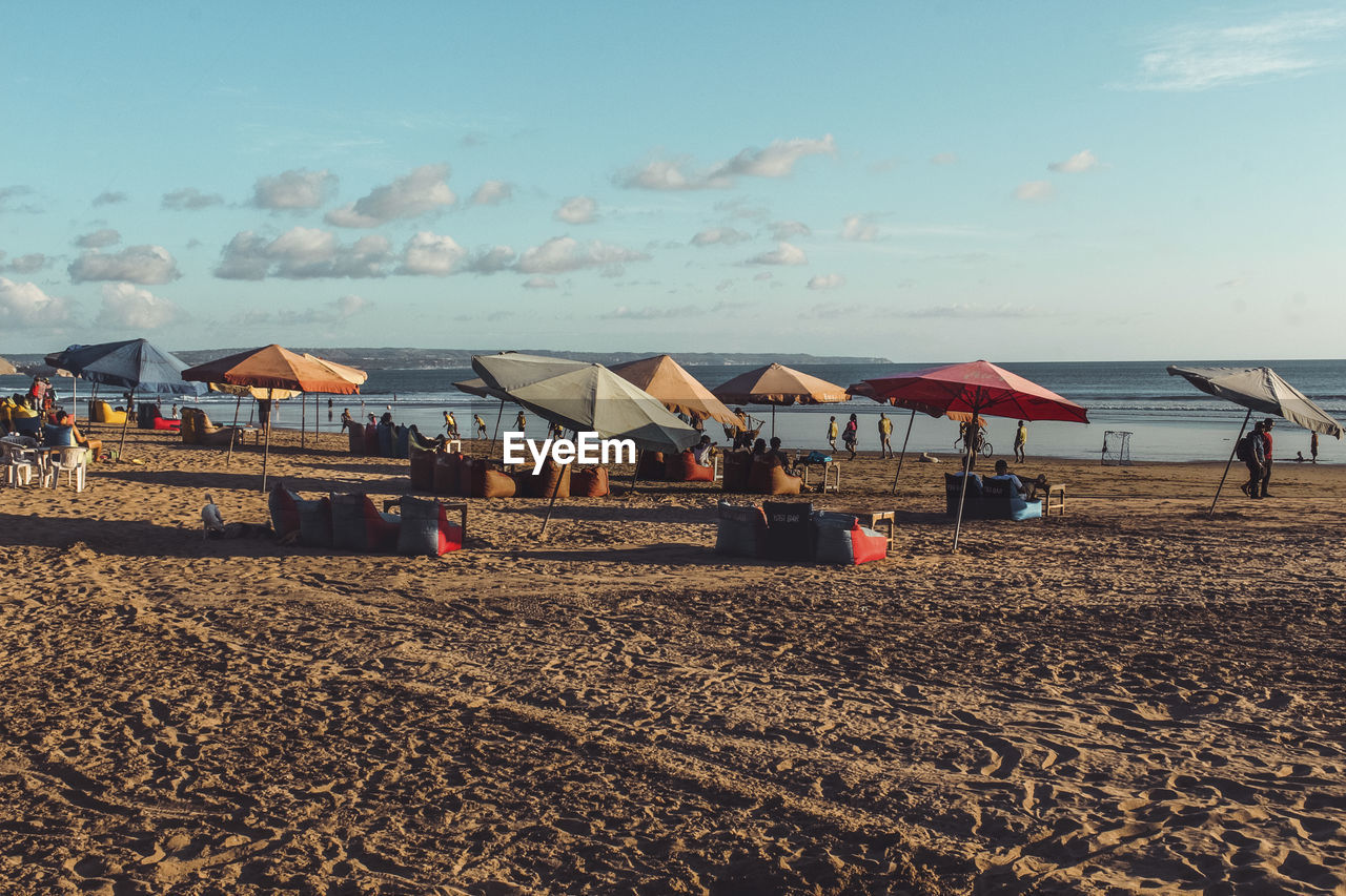 GROUP OF PEOPLE ON BEACH AGAINST SKY