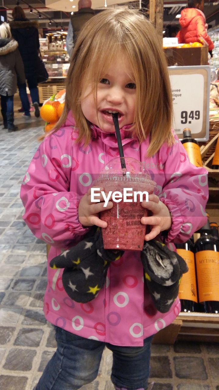 GIRL HOLDING ICE CREAM STANDING AT STORE