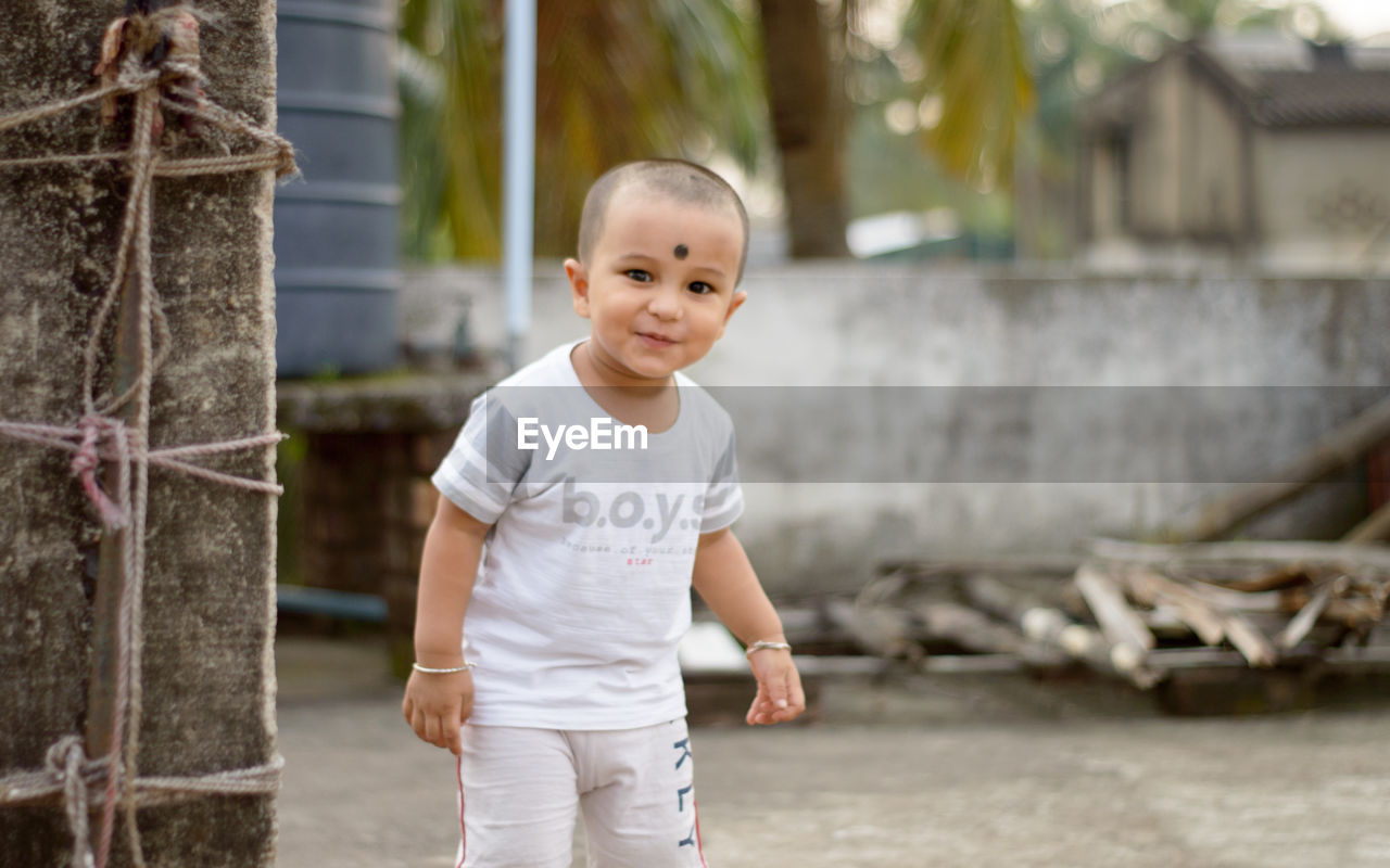 childhood, child, one person, spring, portrait, emotion, smiling, happiness, men, looking at camera, toddler, casual clothing, standing, person, cute, front view, portrait photography, innocence, day, nature, baby, outdoors, lifestyles, tree, cheerful, focus on foreground, architecture, human face, fun, three quarter length, clothing