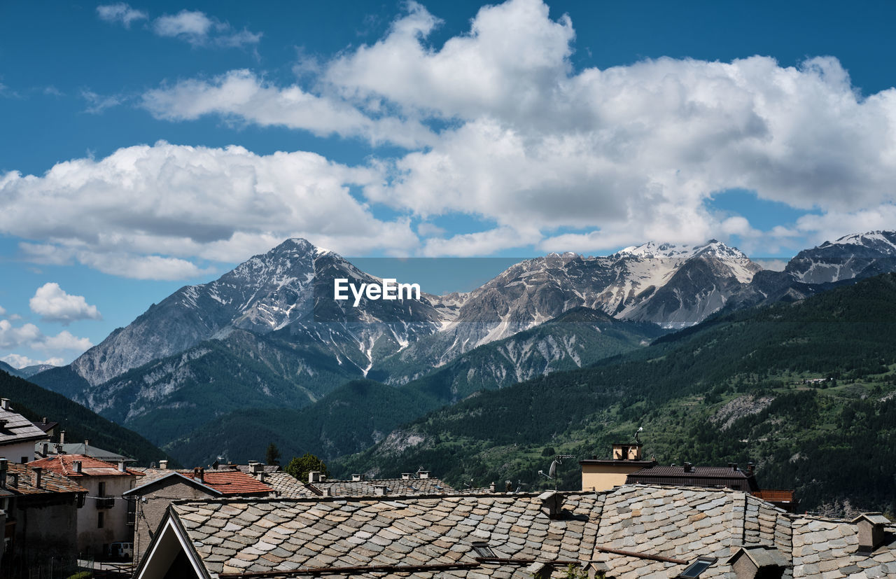 Houses on snowcapped mountain against sky