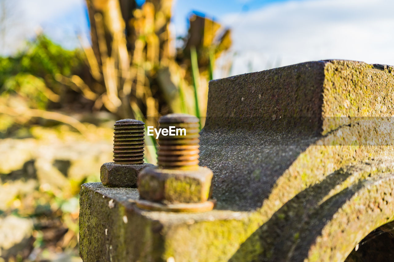 CLOSE-UP OF OLD RUSTY STACK AGAINST METAL