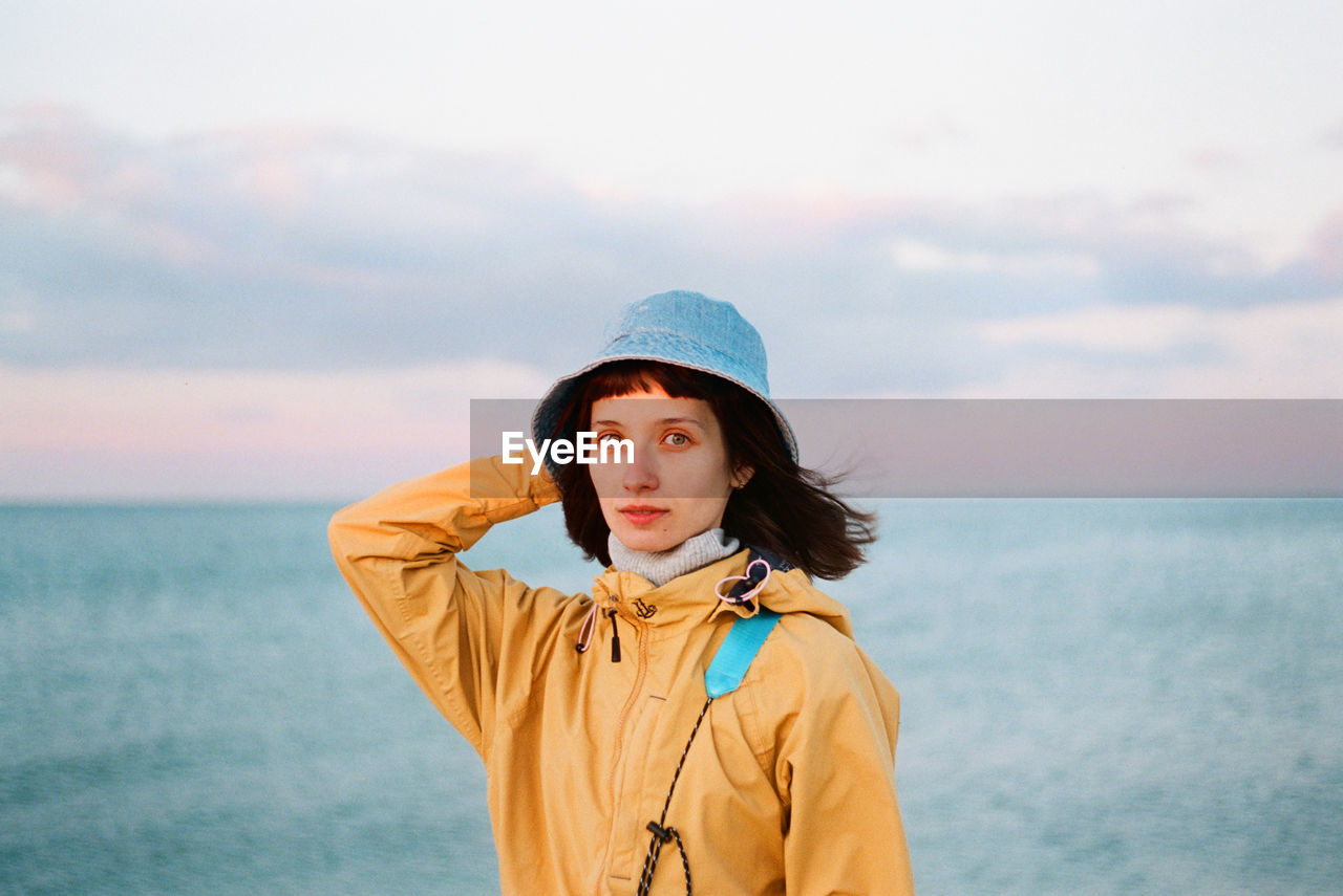 Portrait of woman standing in sea against sky