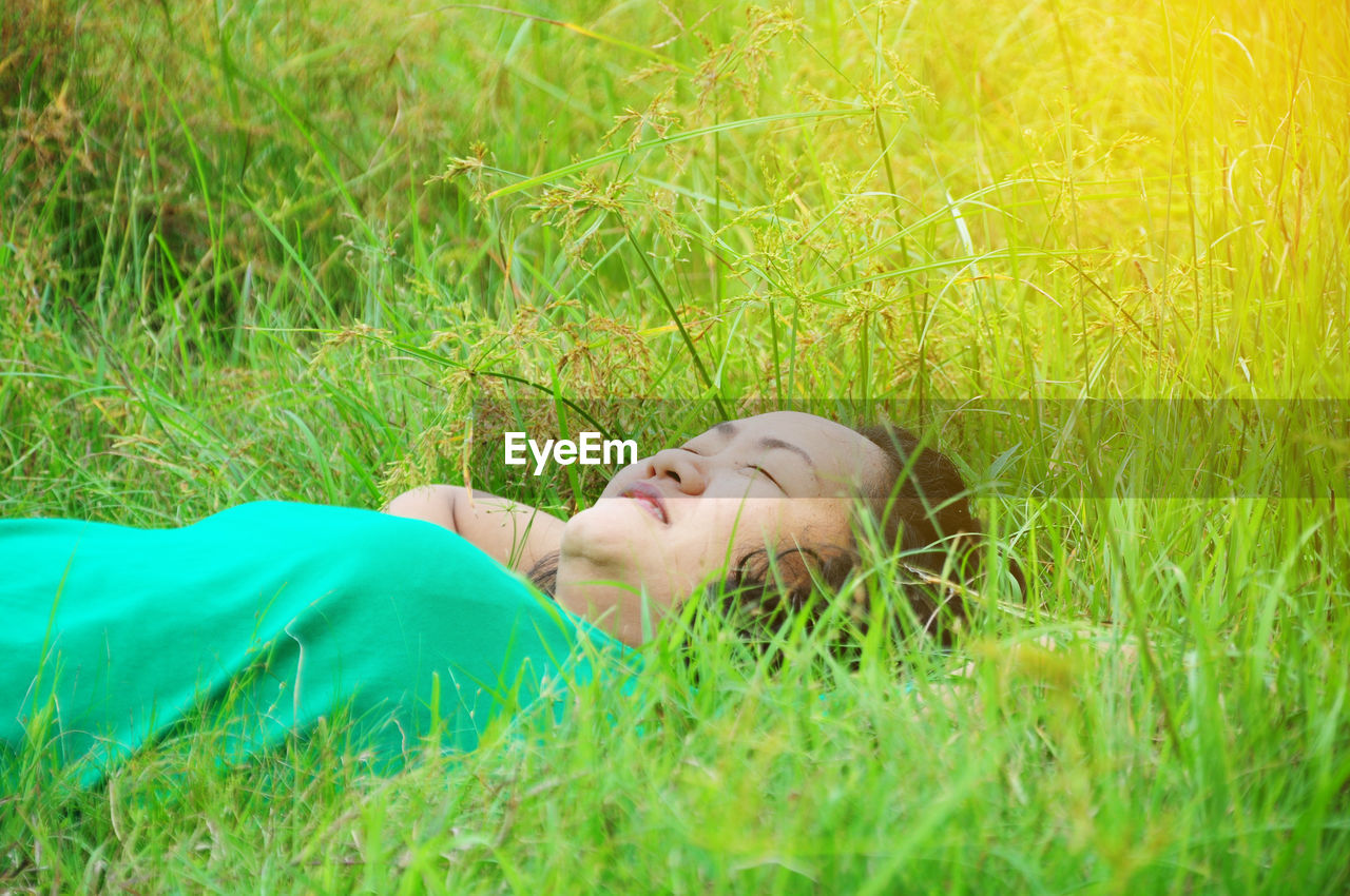 Woman relaxing on grassy field