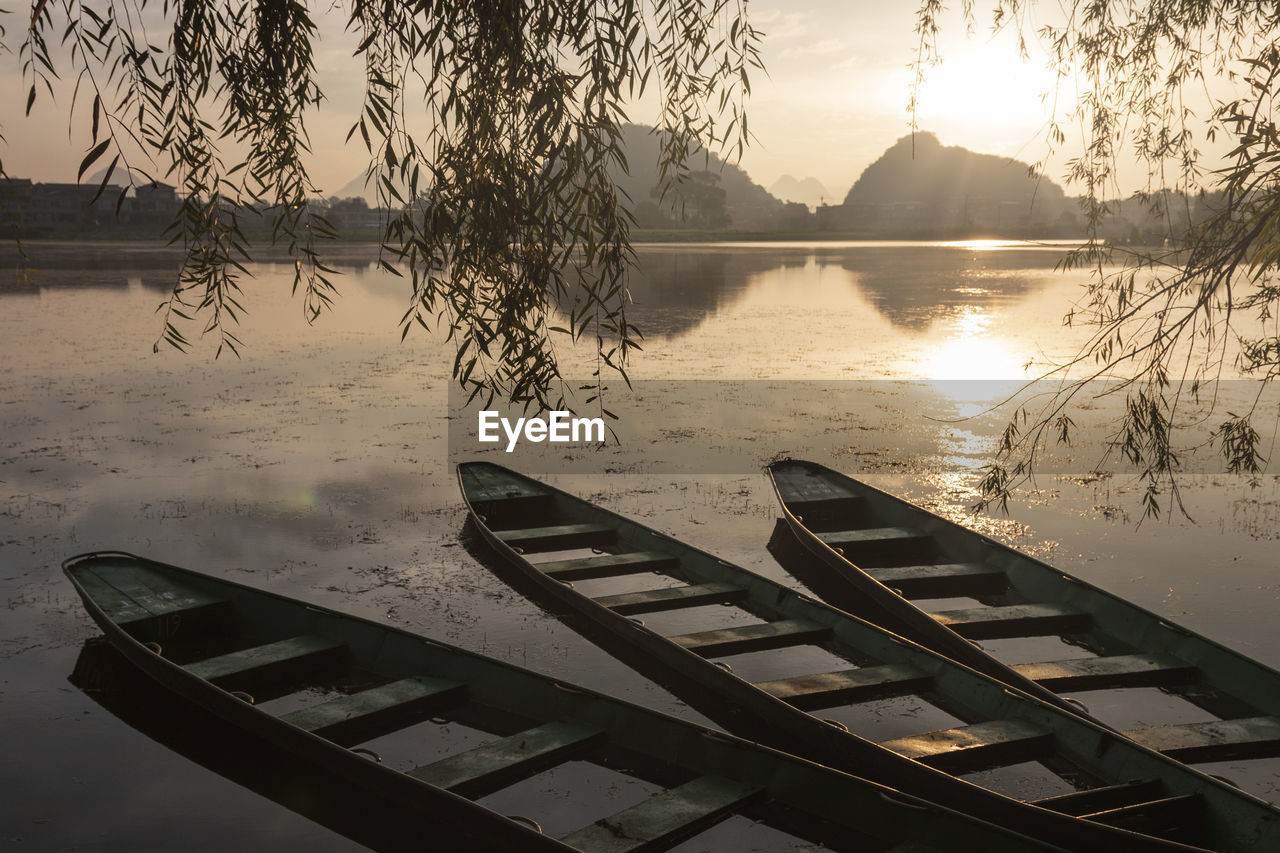 Wooden boats at sunrise in puzhehei - yunnan, china