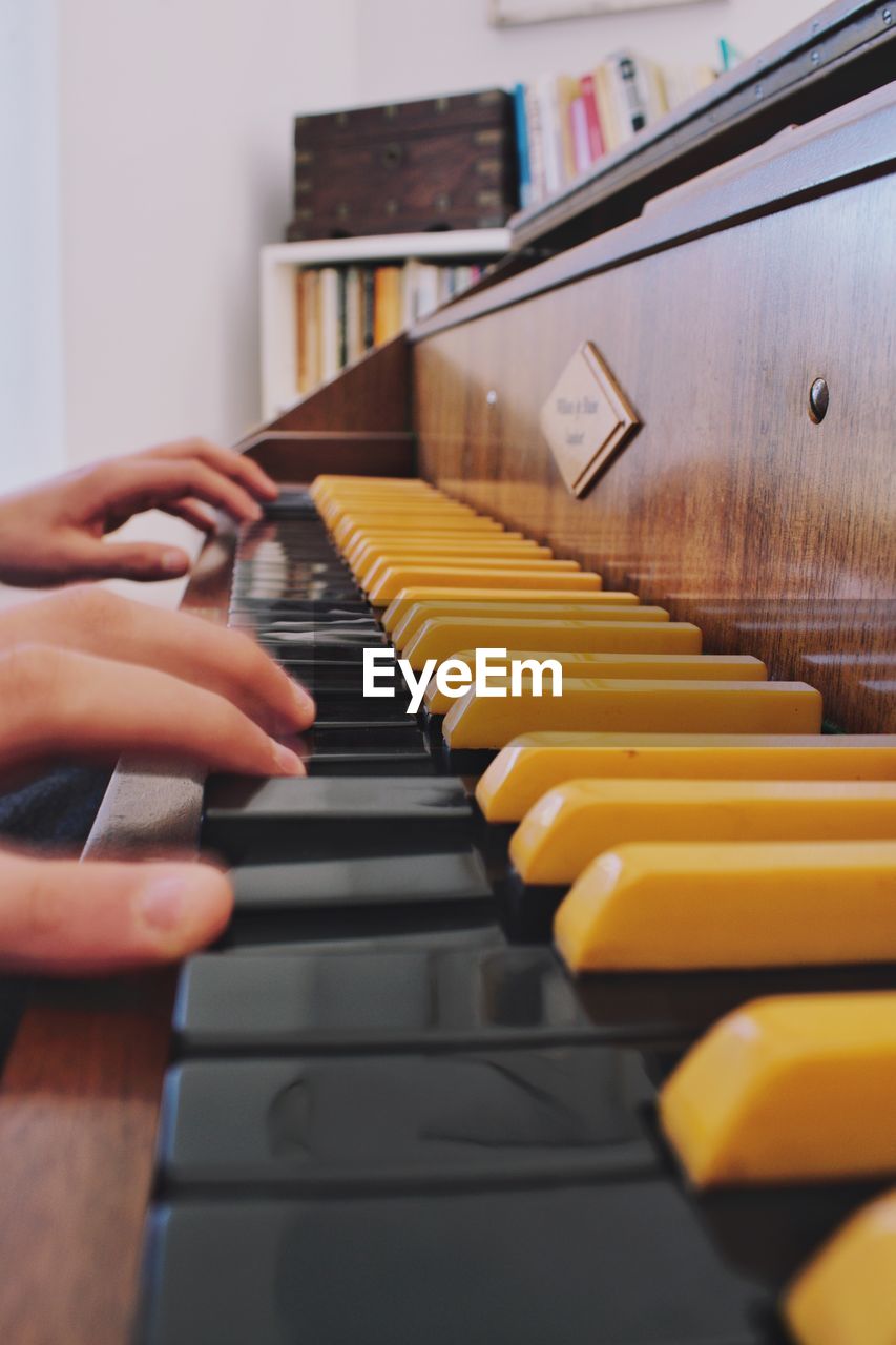 Cropped hands of person playing piano