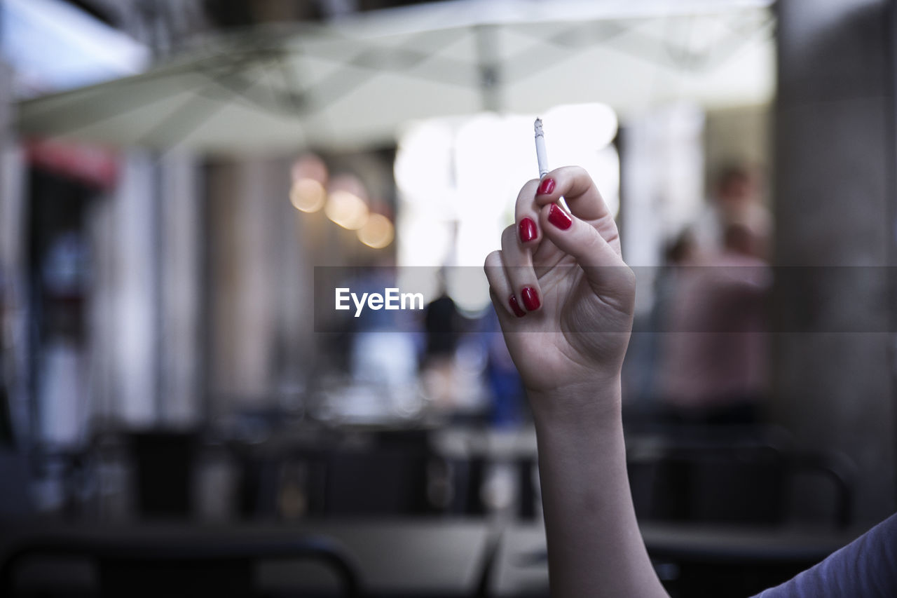 Cropped image of hand holding cigarette