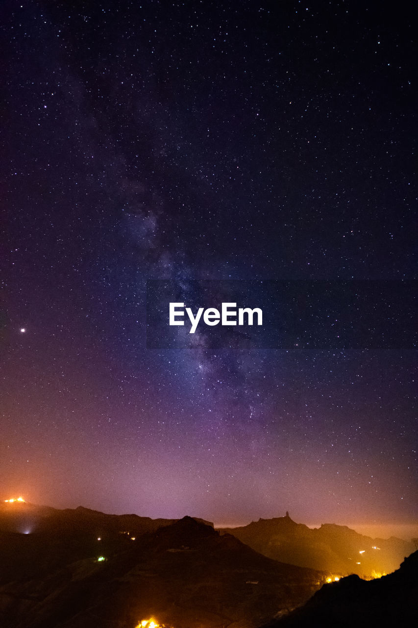 Illuminated mountains against sky at night