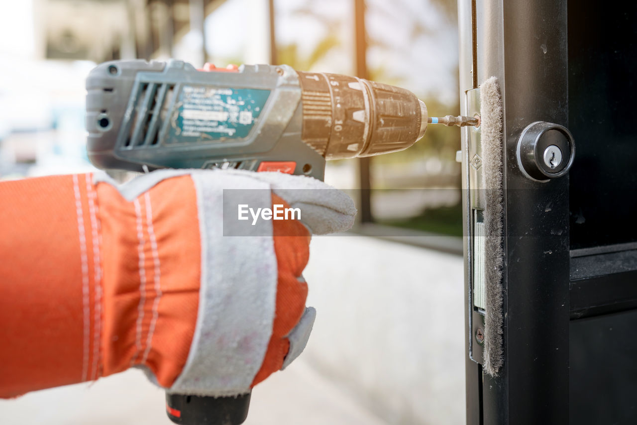 Close-up of hand drilling door