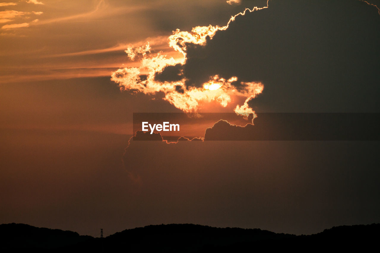 Scenic view of silhouette mountains against orange sky