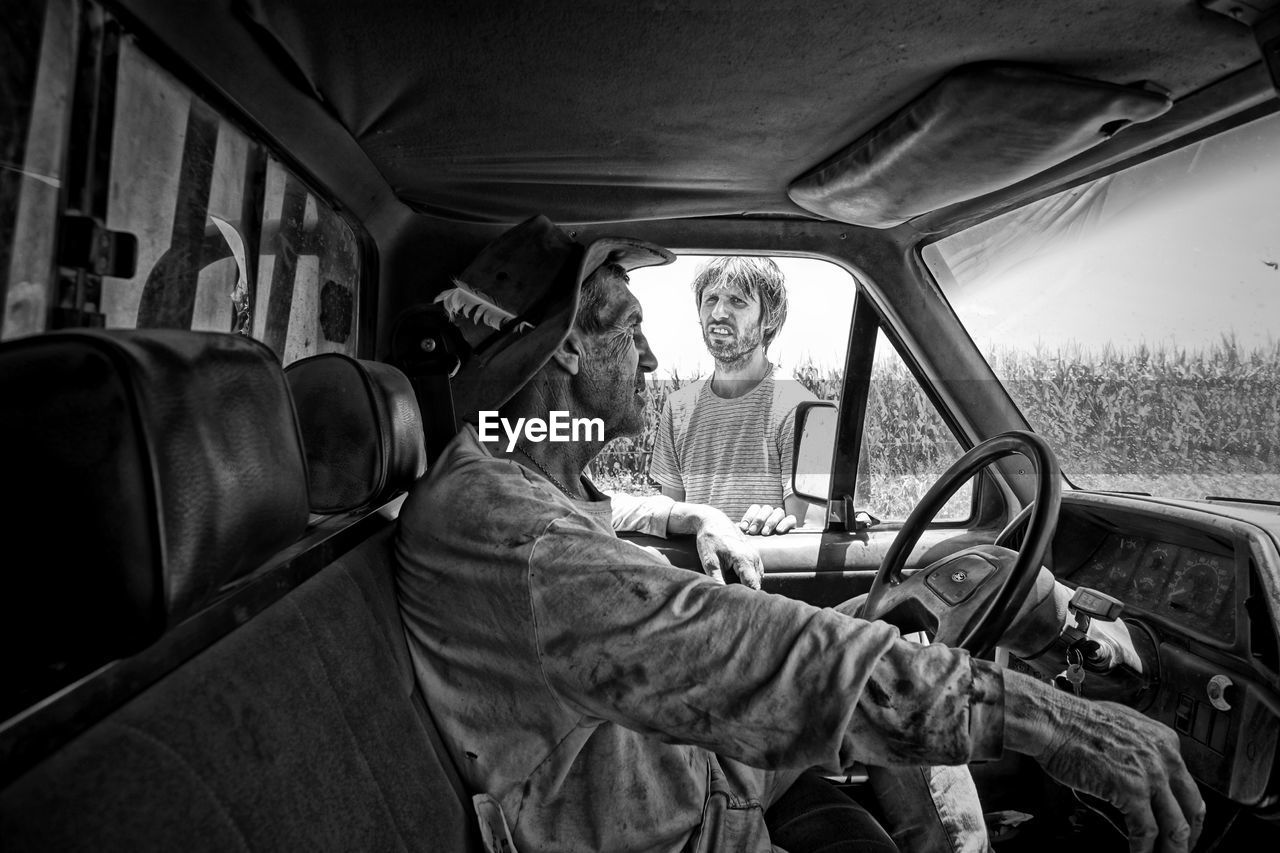 Young man talking with truck driver