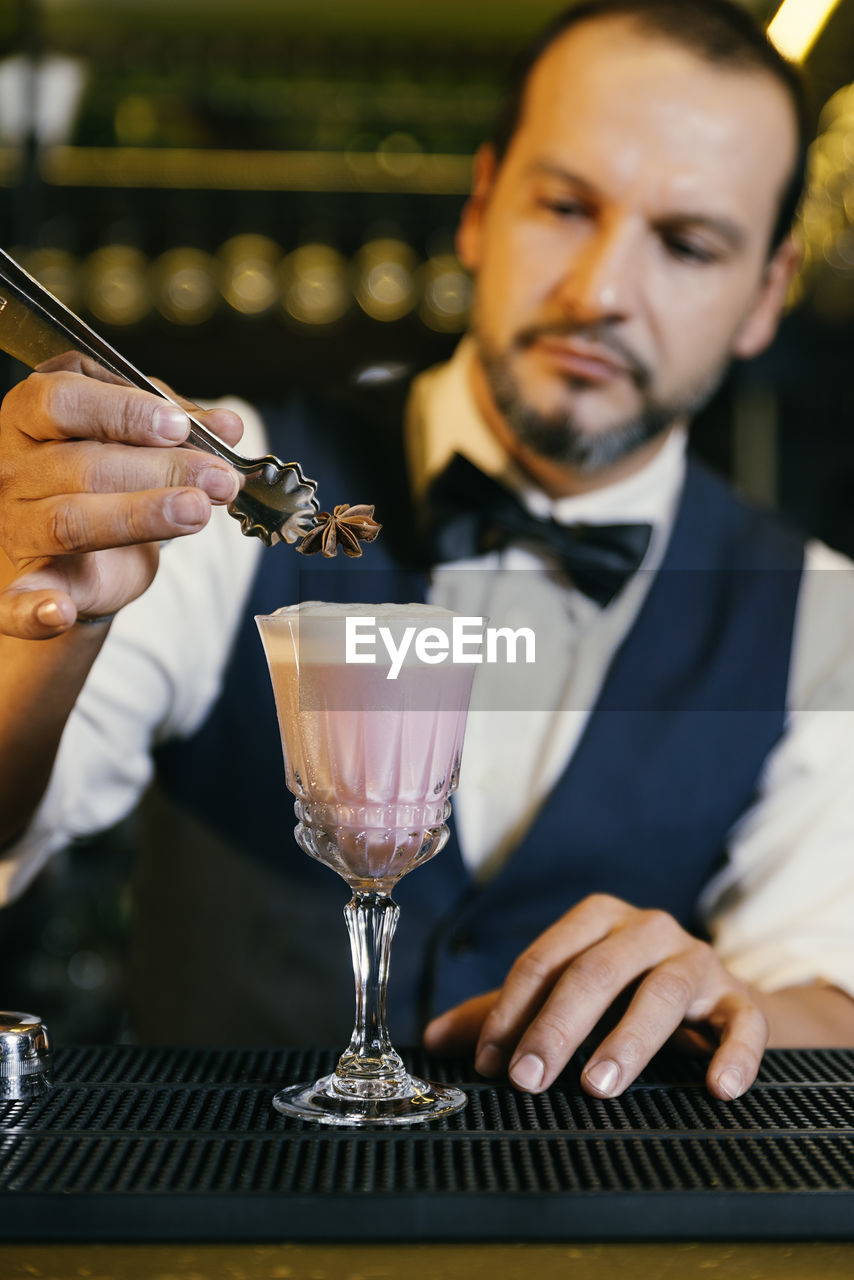 Bartender making drink on counter in bar