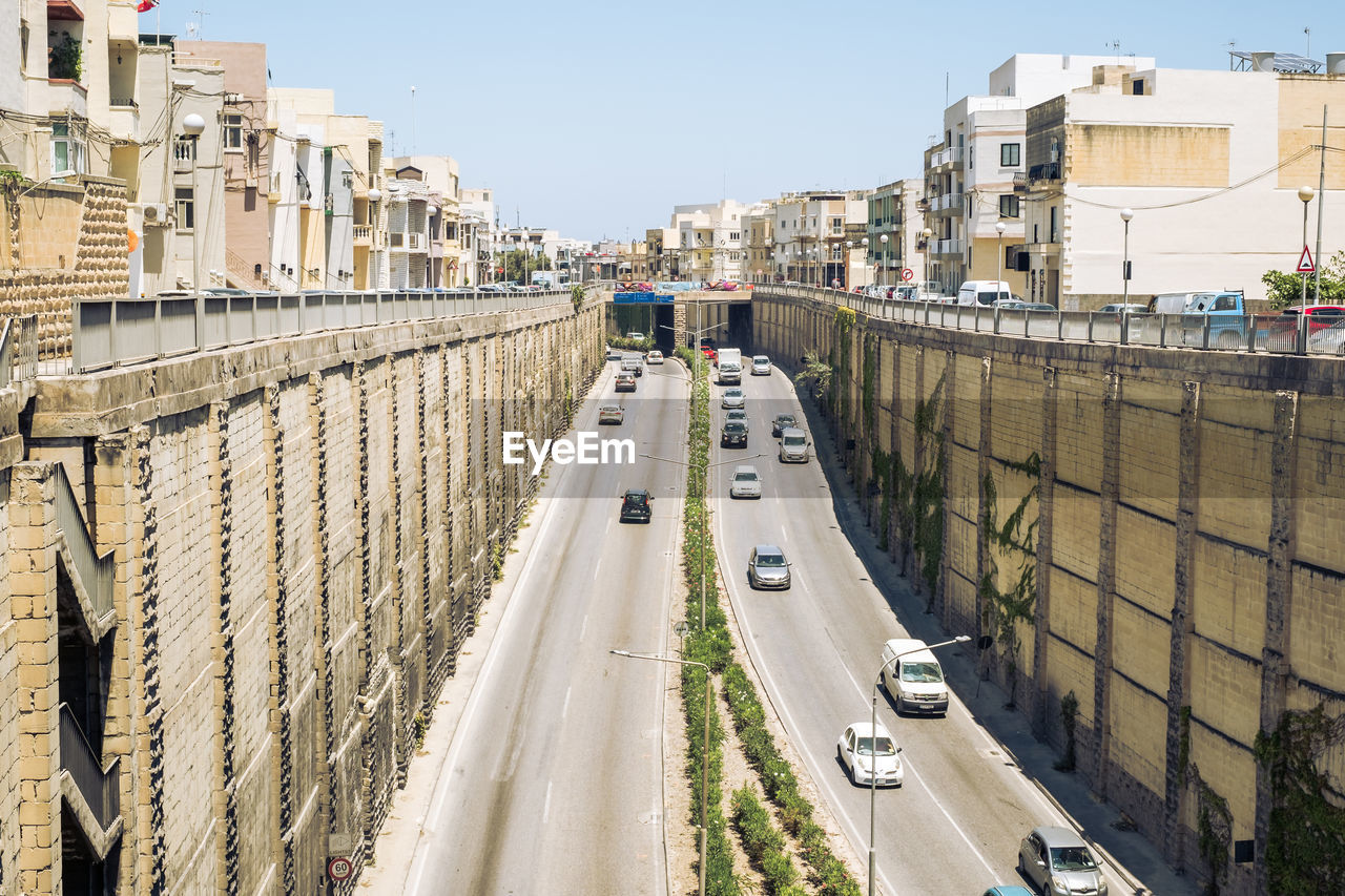 HIGH ANGLE VIEW OF STREET AMIDST BUILDINGS