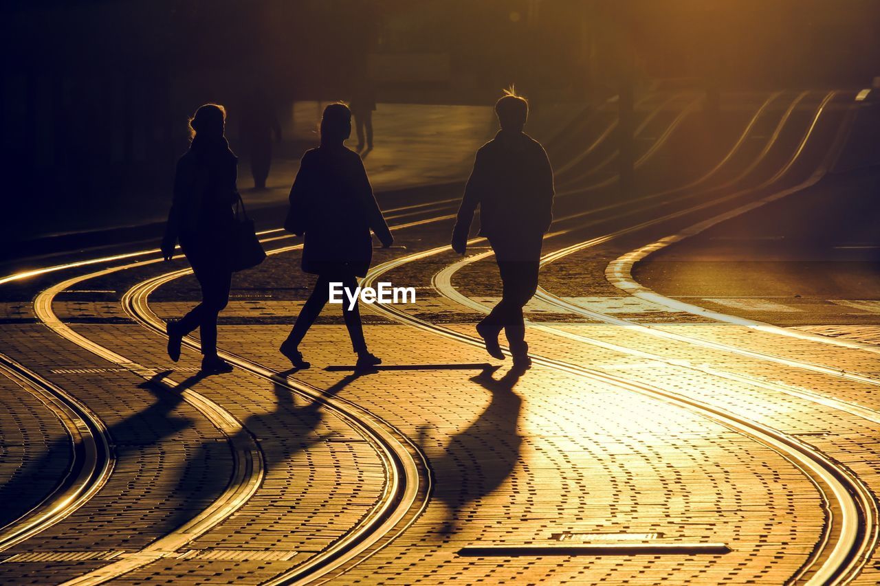 People walking at railway track on road