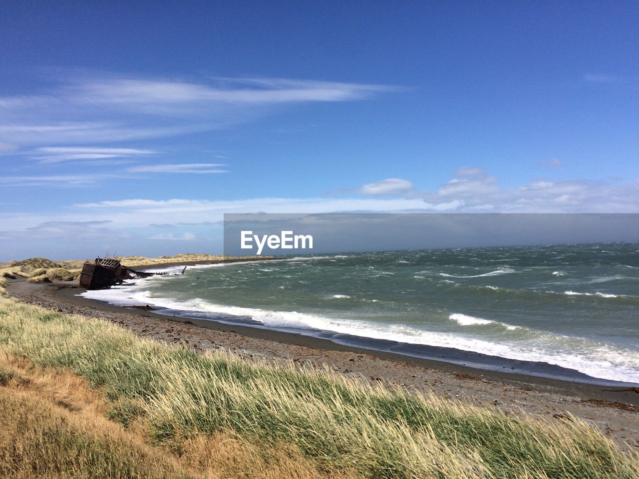 SCENIC VIEW OF BEACH AGAINST BLUE SKY