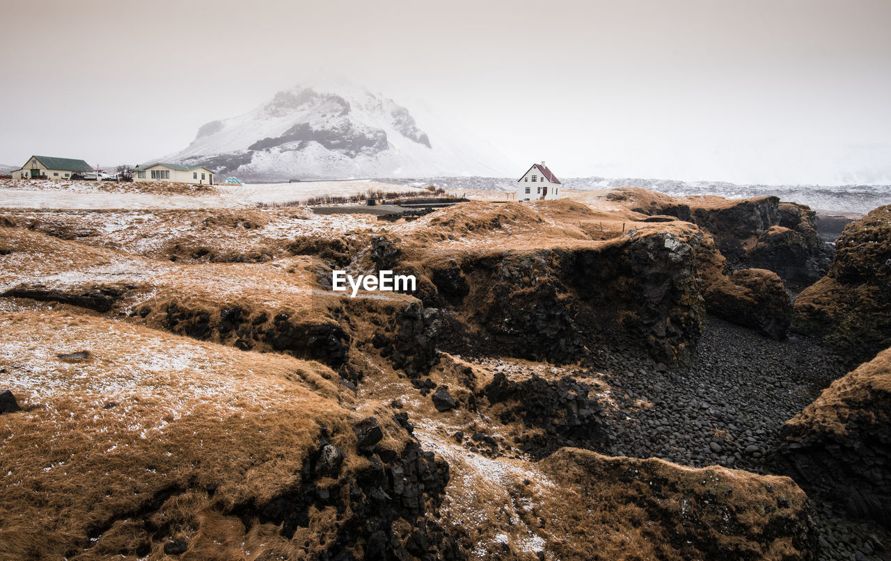 Scenic view of snowcapped mountain by sea against sky