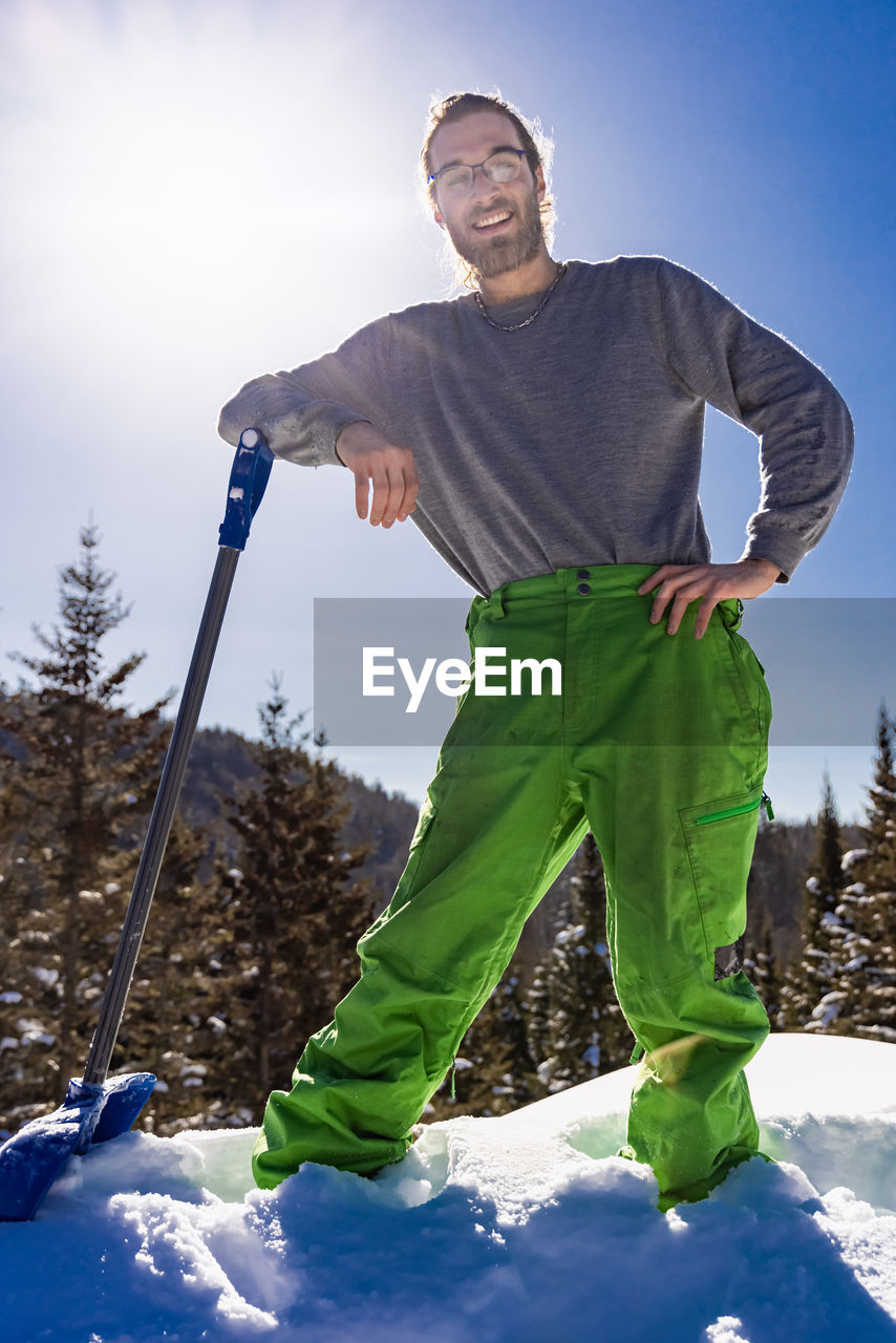 YOUNG MAN STANDING ON SNOW COVERED LAND