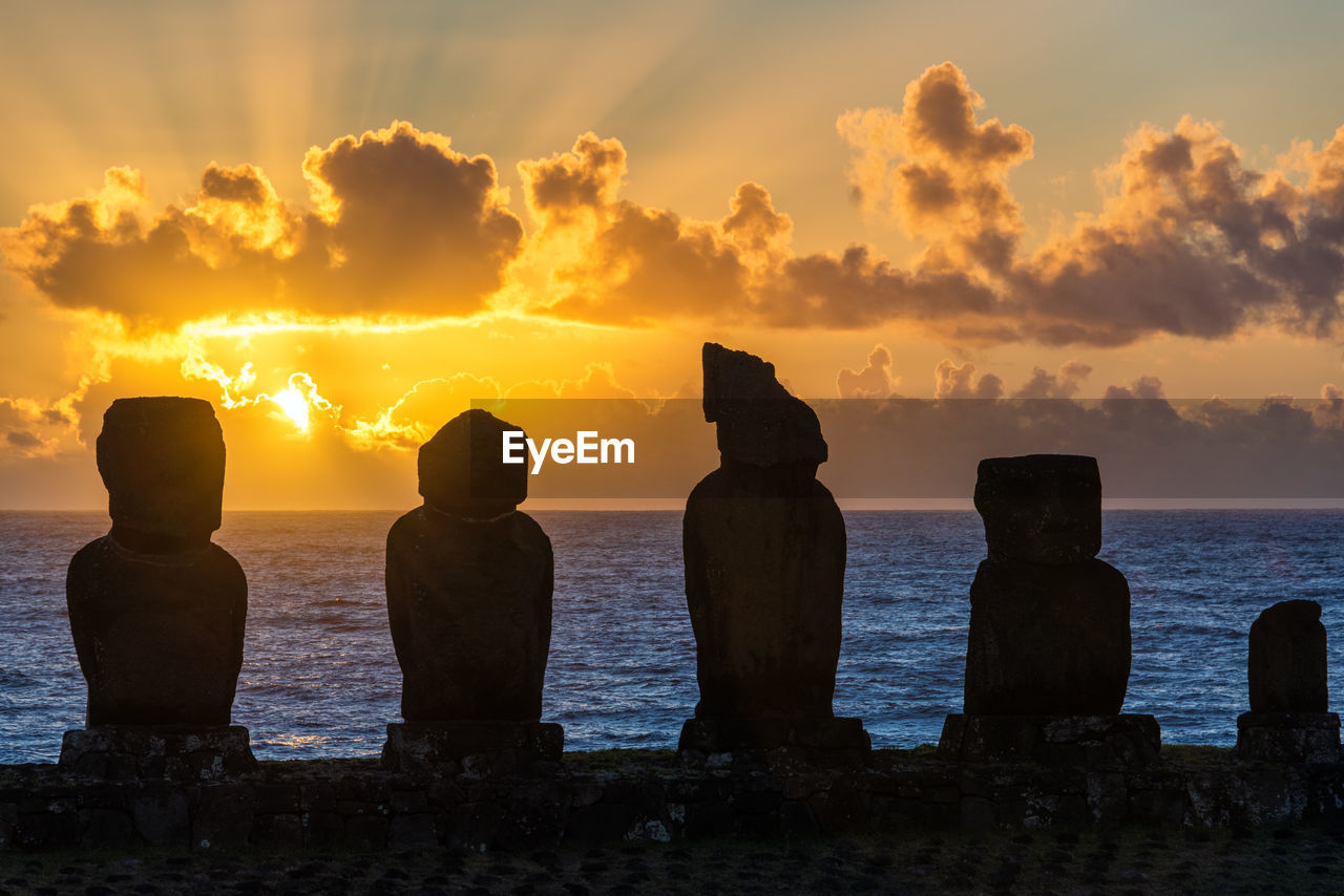 Silhouette ahu tahai statues at easter island against sky during sunset