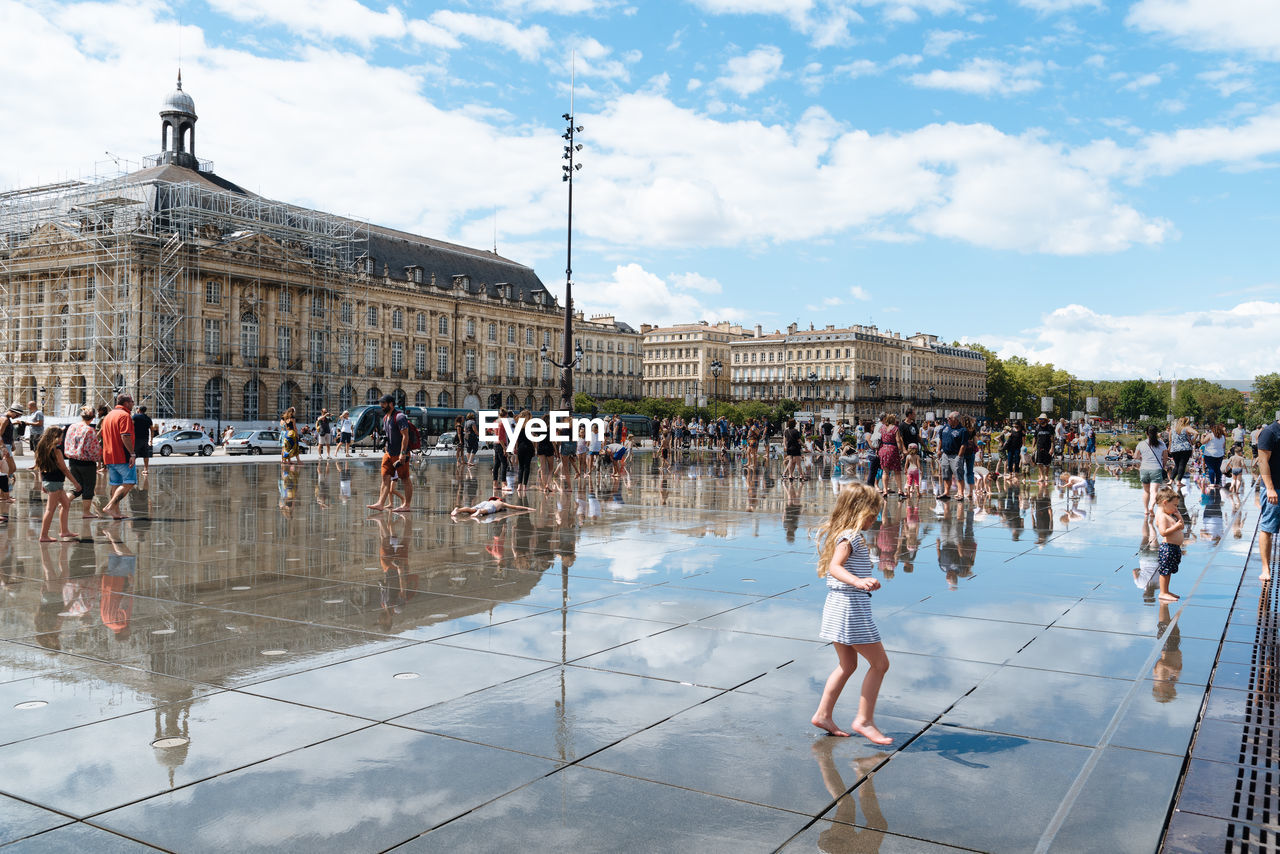 PEOPLE IN FRONT OF BUILDINGS AGAINST SKY