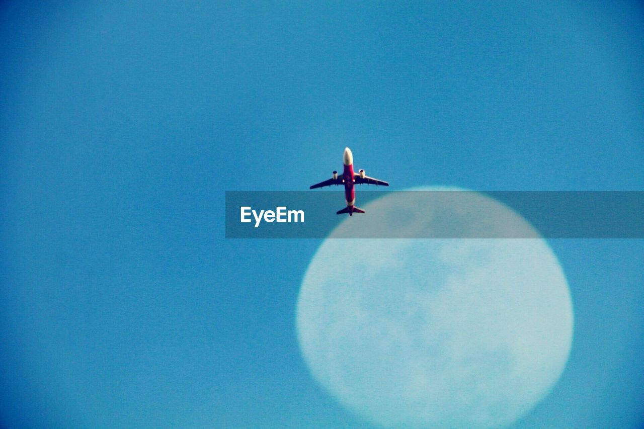 LOW ANGLE VIEW OF AIRPLANE FLYING IN CLEAR SKY