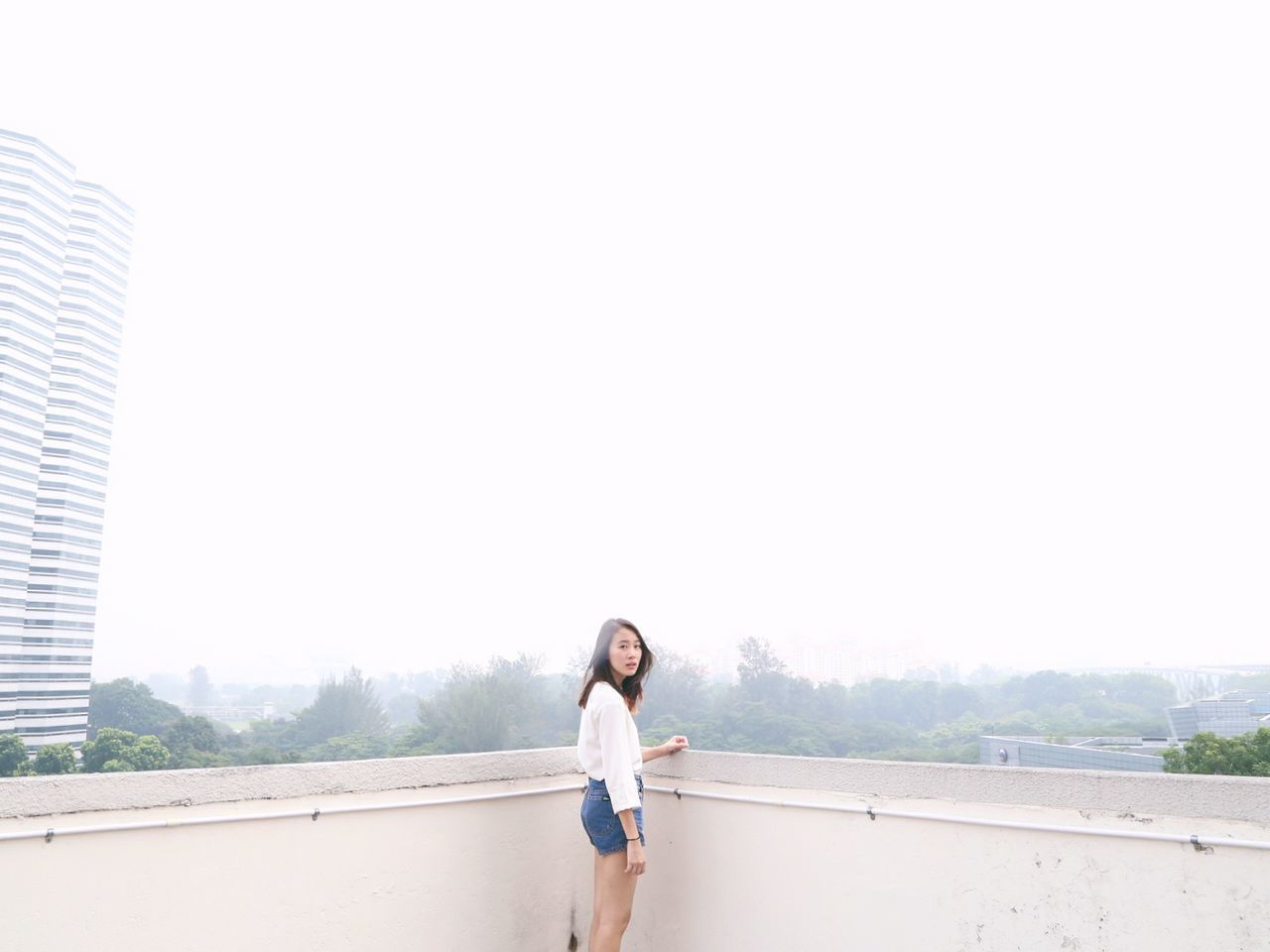 YOUNG WOMAN STANDING ON WALL