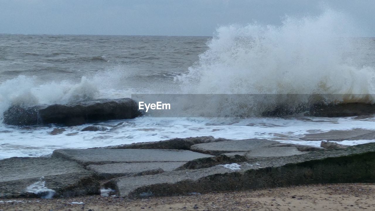 Scenic view of splashing sea waves at dusk