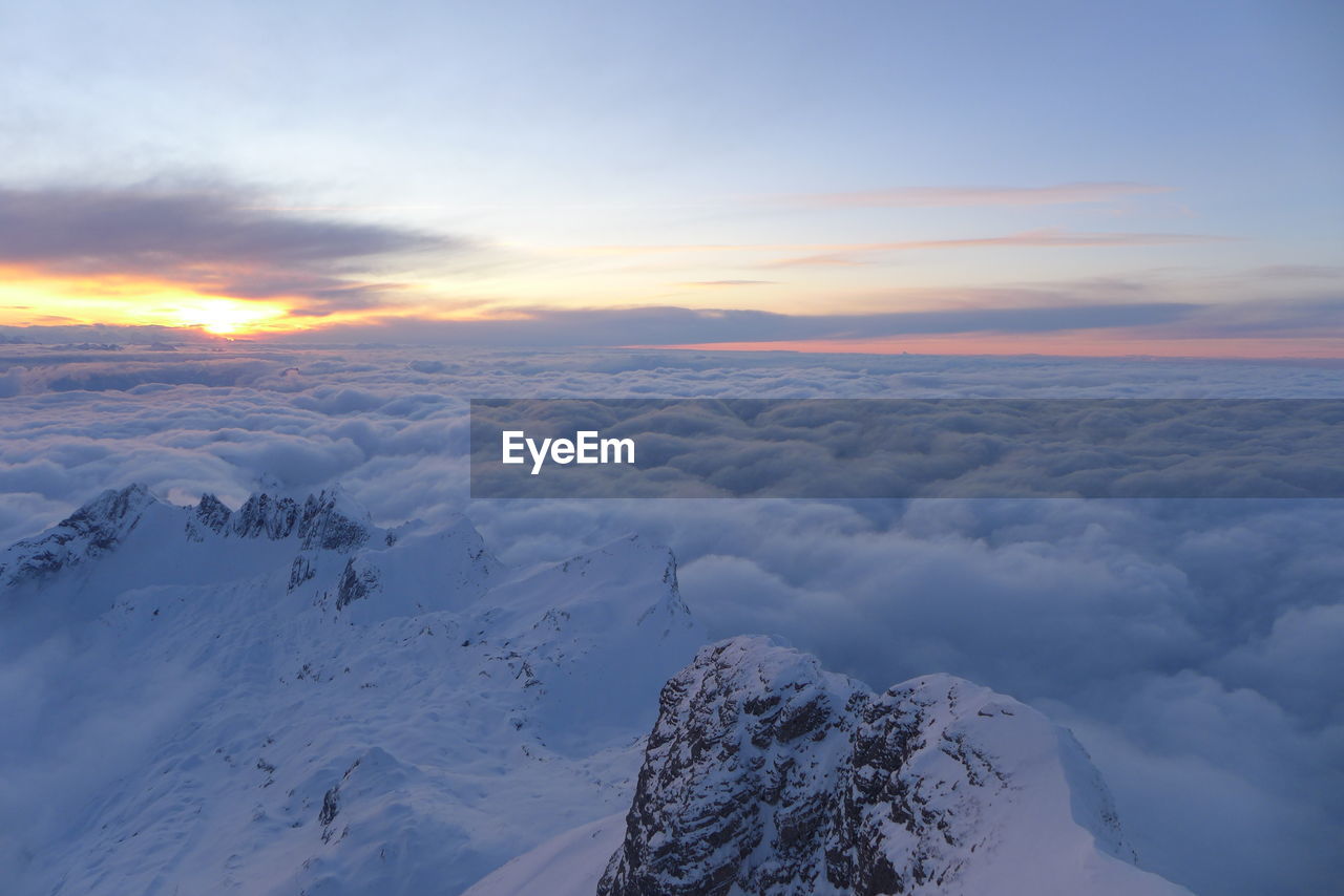 Scenic view of snowcapped mountains against sky during sunset