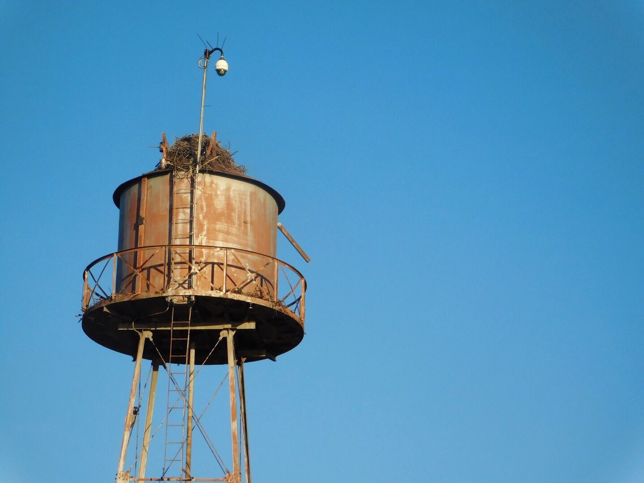 Low angle view of water tower against clear blue sky