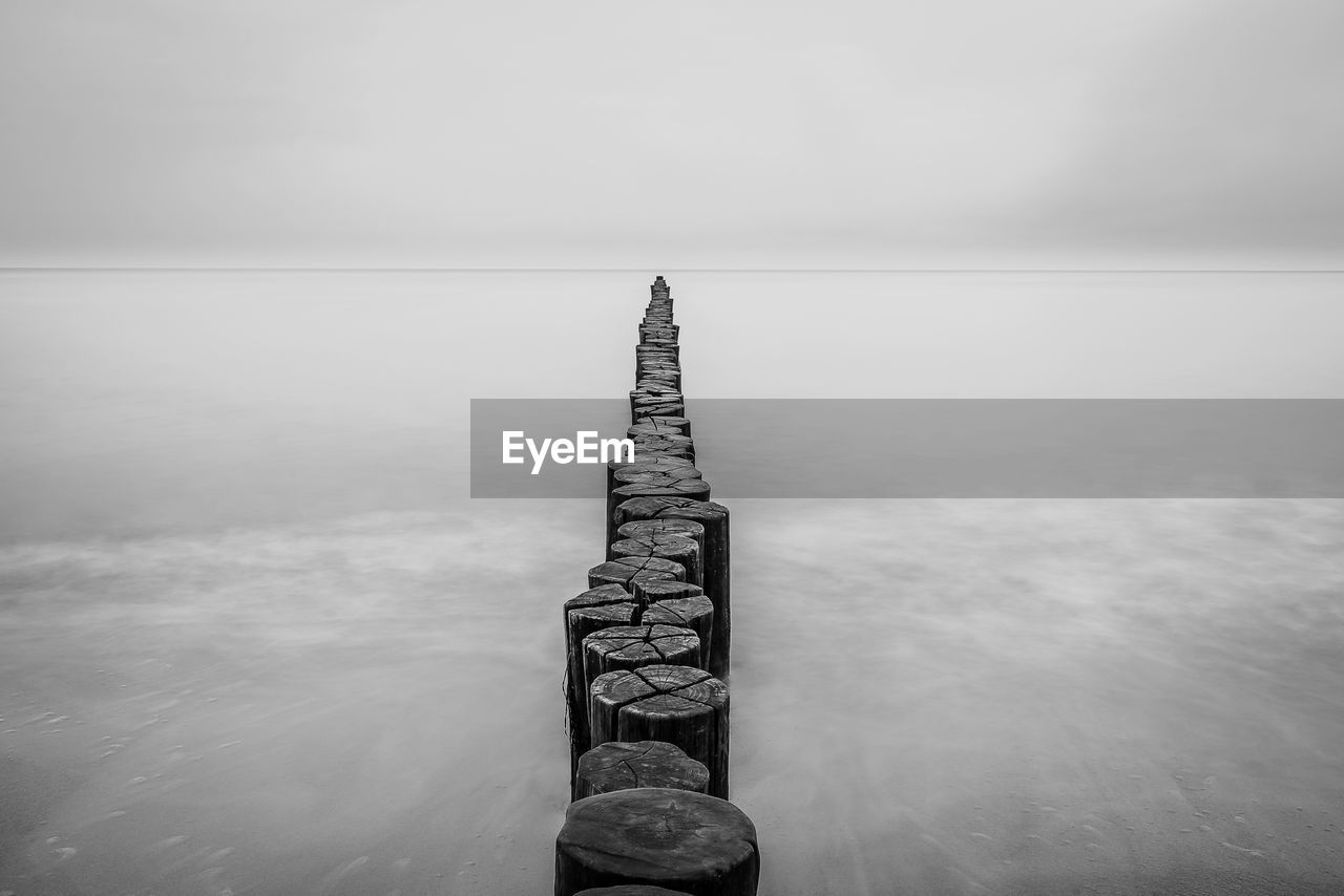 View of groyne in sea against sky