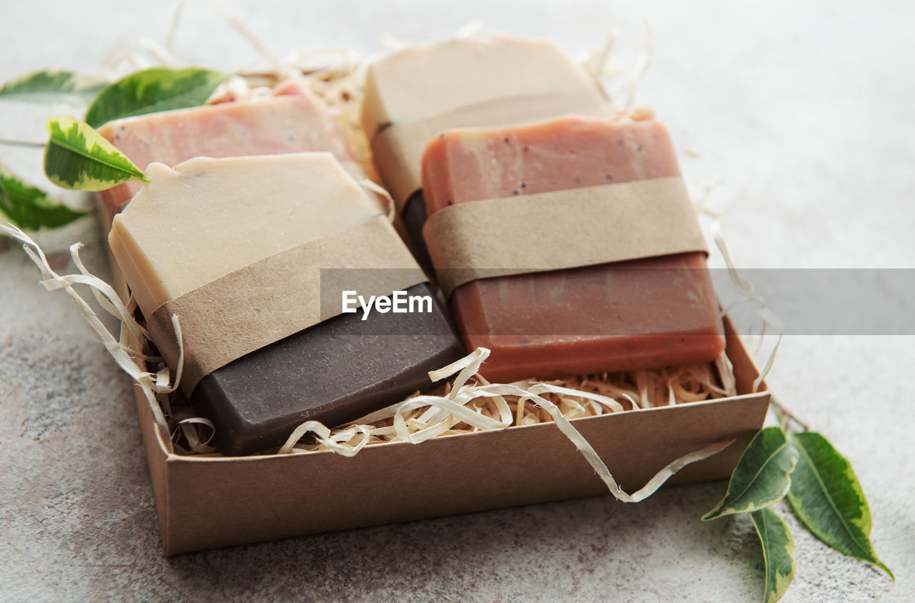 Assorted handmade soap bars and green leaves