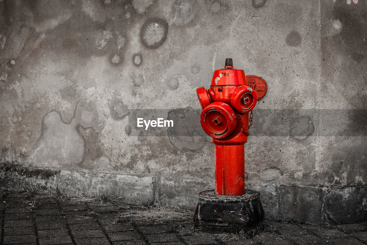 Red fire hydrant against wall