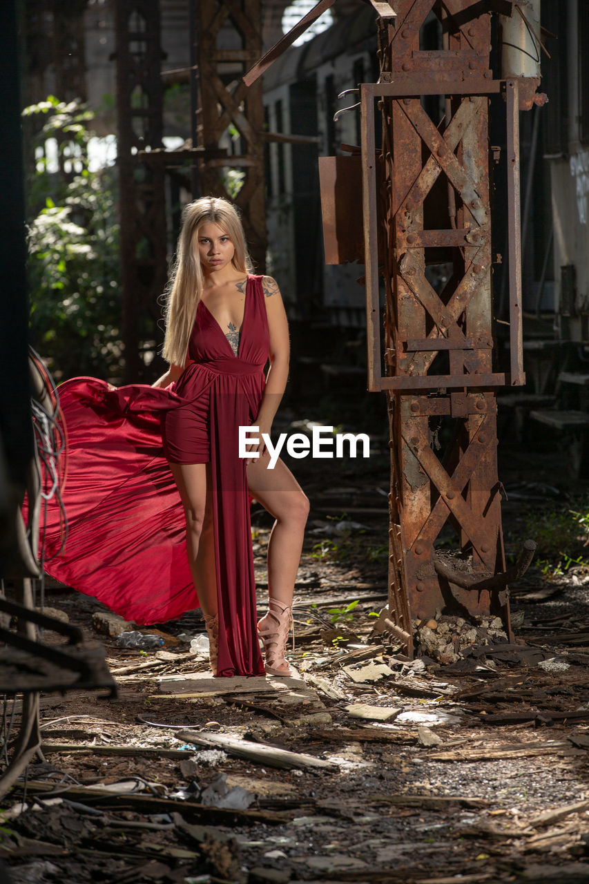 Portrait of woman standing in old abandoned rusty train yard