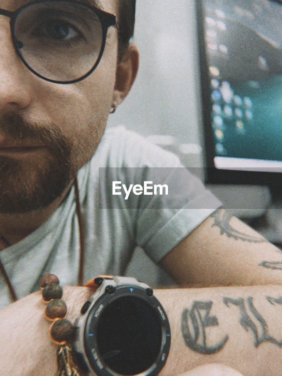 one person, glasses, adult, men, vision care, eyeglasses, technology, portrait, indoors, person, headshot, lifestyles, hand, beard, facial hair, cool, arm, young adult, looking, occupation, close-up, tattoo, leisure activity, eyewear, sunglasses, casual clothing, communication, front view