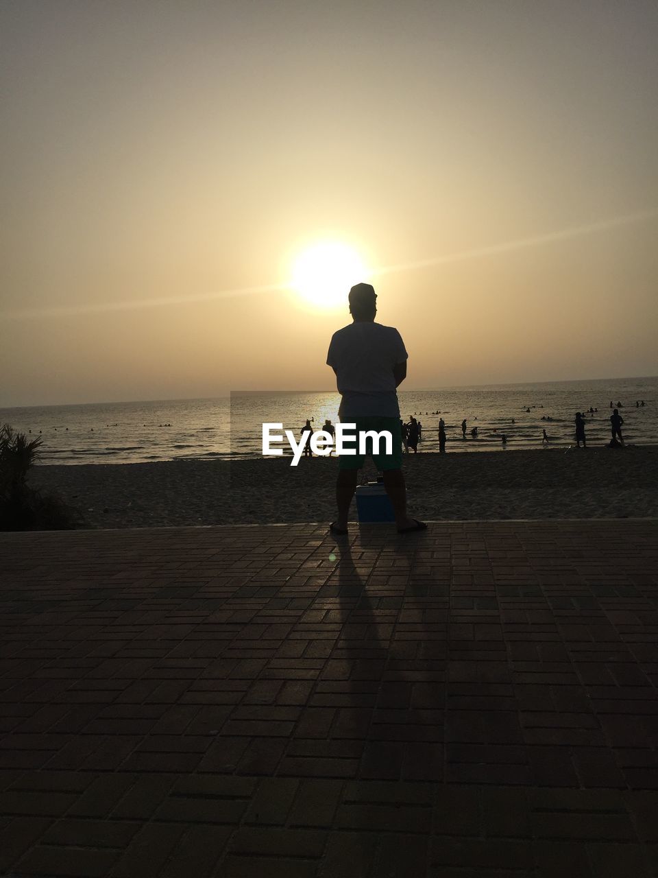 Silhouette man on beach against clear sky during sunset