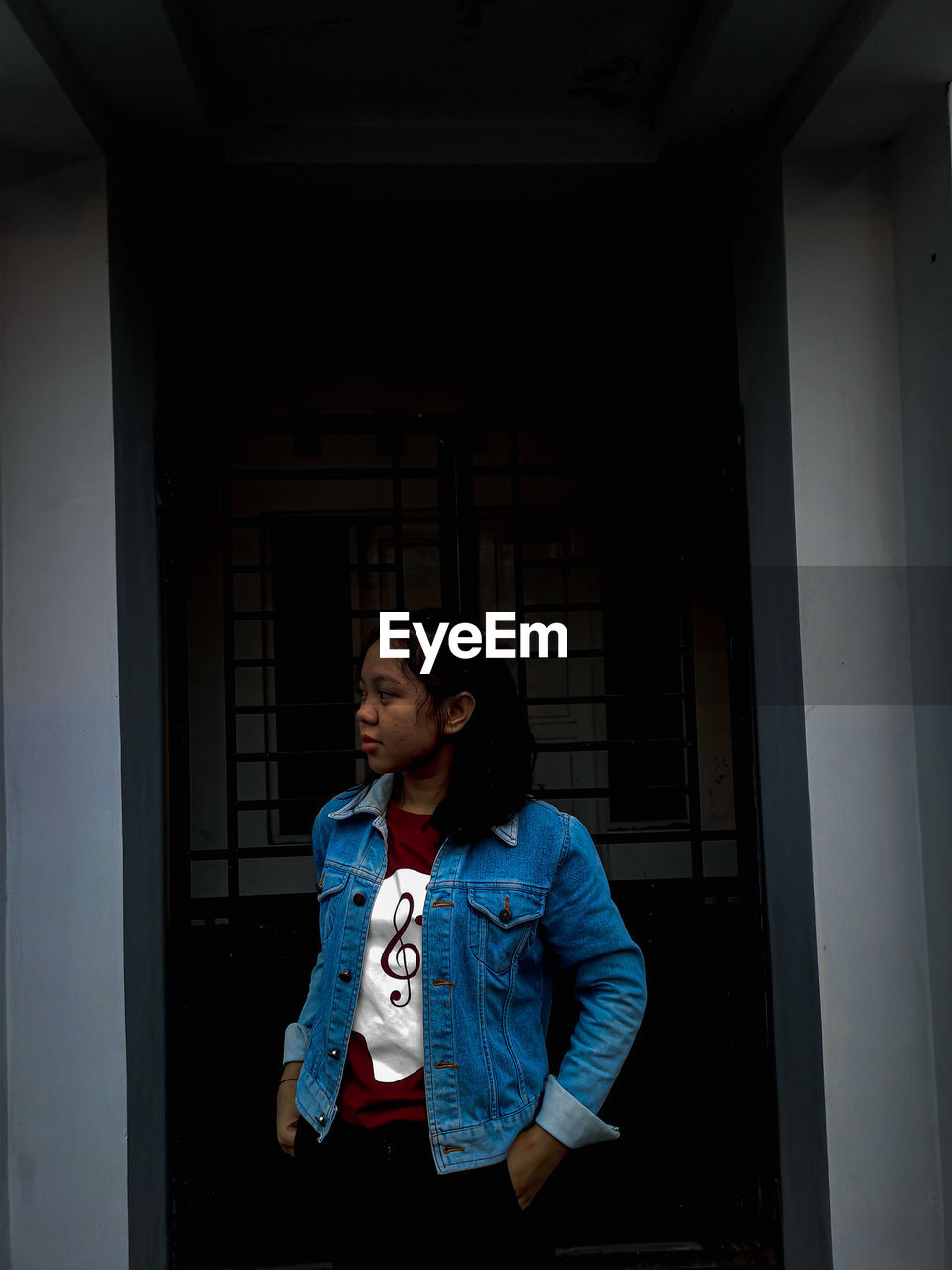 FULL LENGTH OF TEENAGE BOY LOOKING THROUGH WINDOW