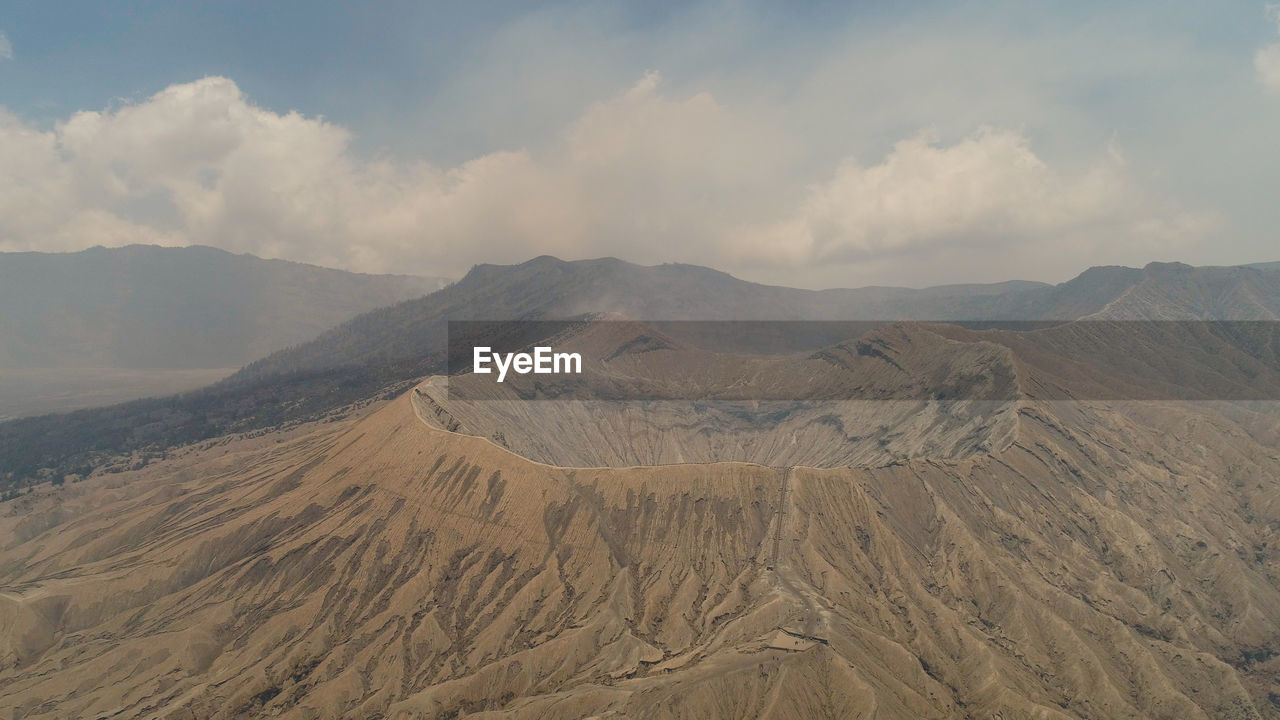 Active volcano bromo with smoking crater. volcano crater and mountains tengger semeru national park.